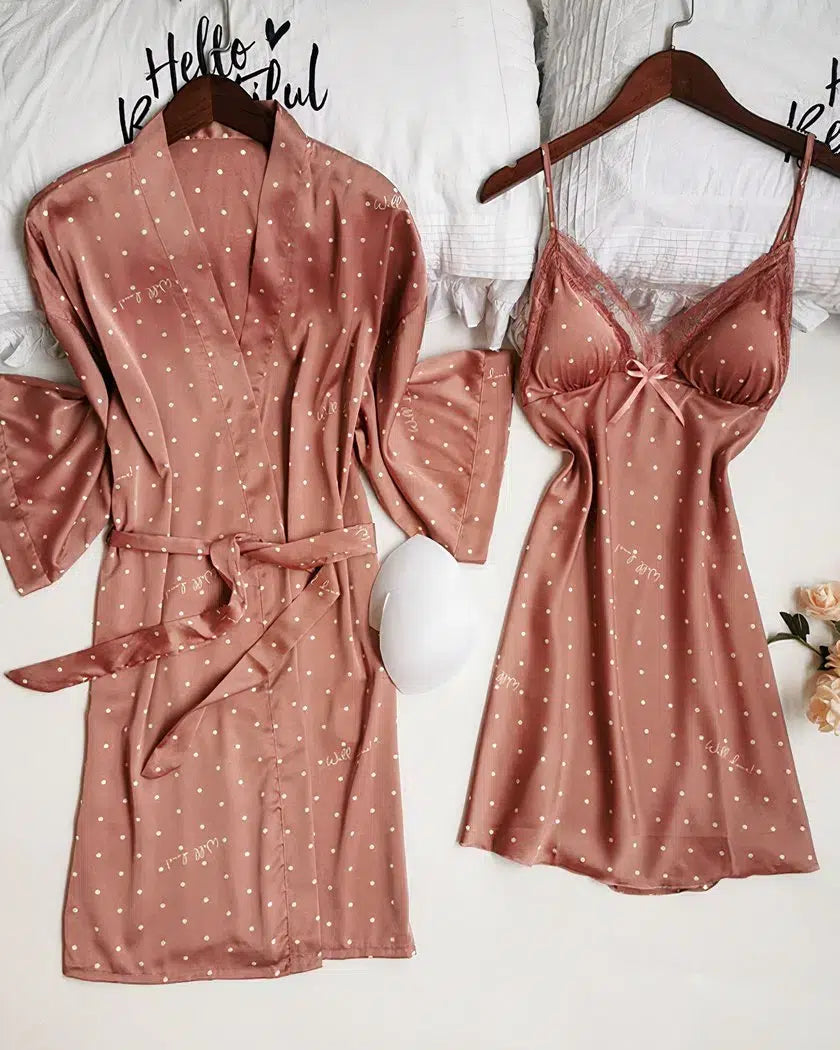 Ensemble nuisette et kimono en satin rose à pois présenté à plat sur le lit