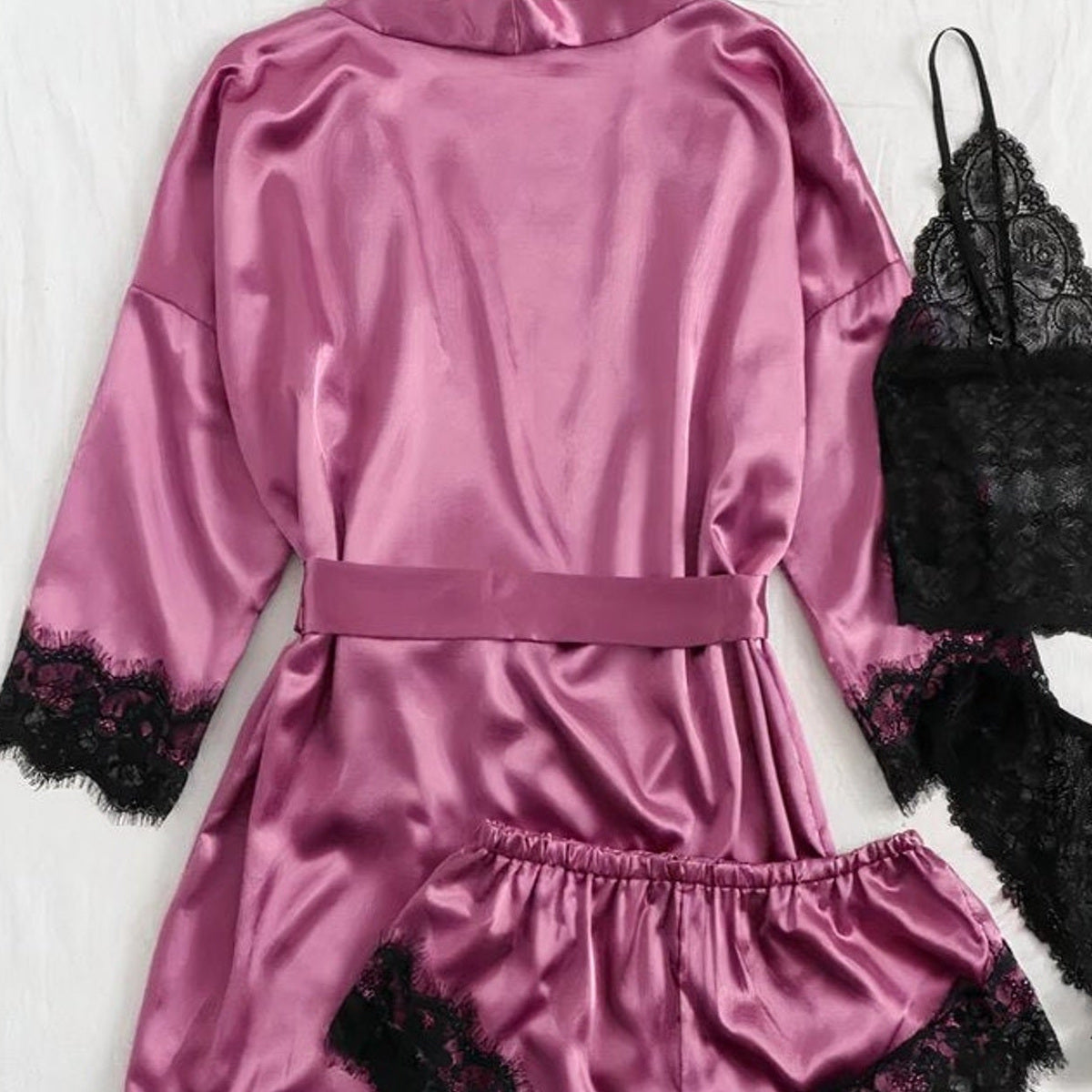 Les quatre pièces rose mauve et noires de l’ensemble pyjama satin et dentelle Image