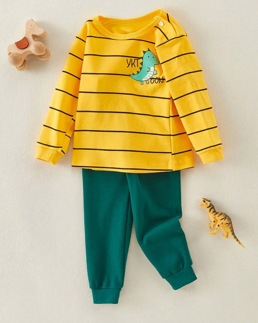 Pyjama garçon dinosaure posé à plat, haut jaune rayé et pantalon vert