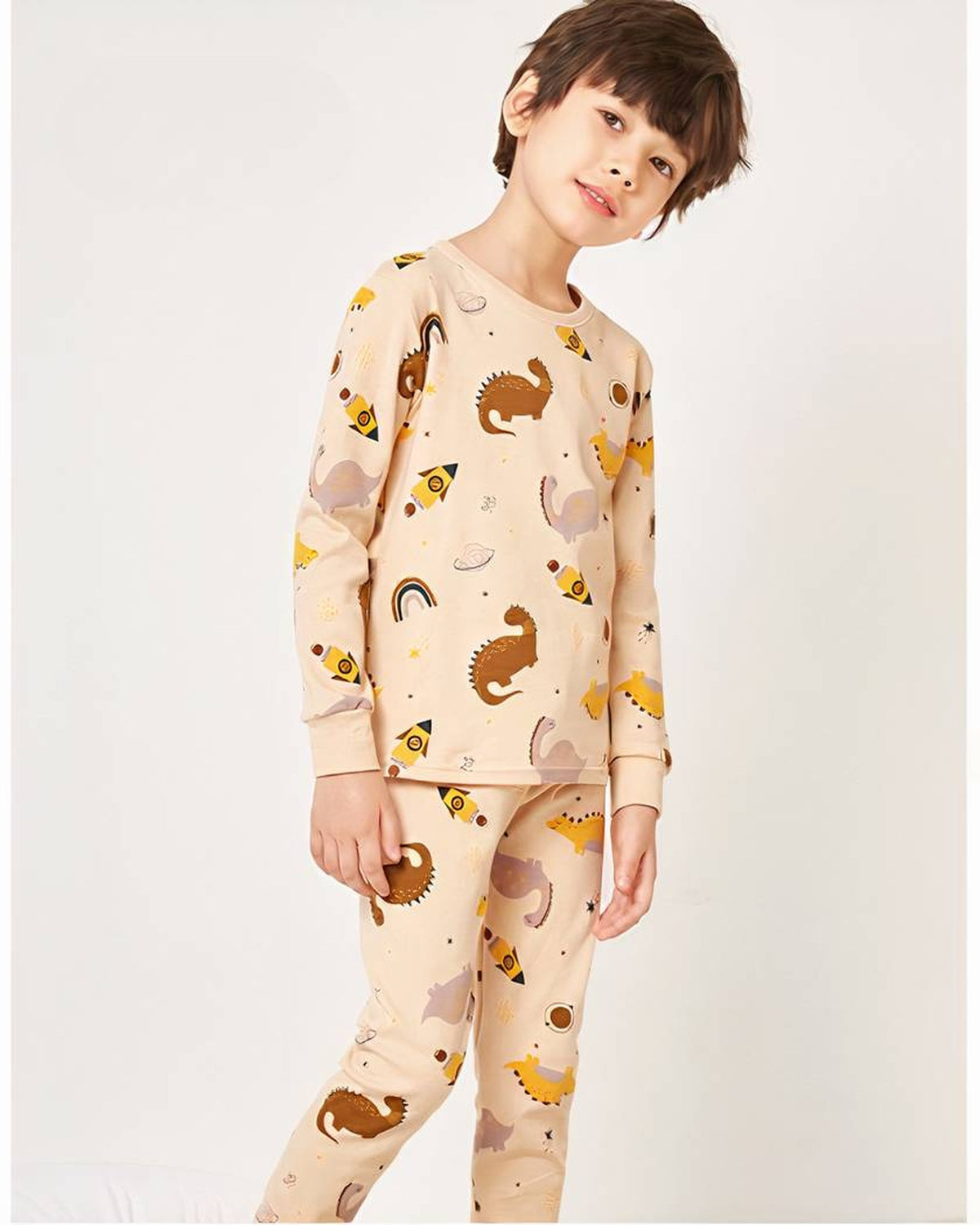 Garcon en pyjama dinosaures beige theme espace, pose debout