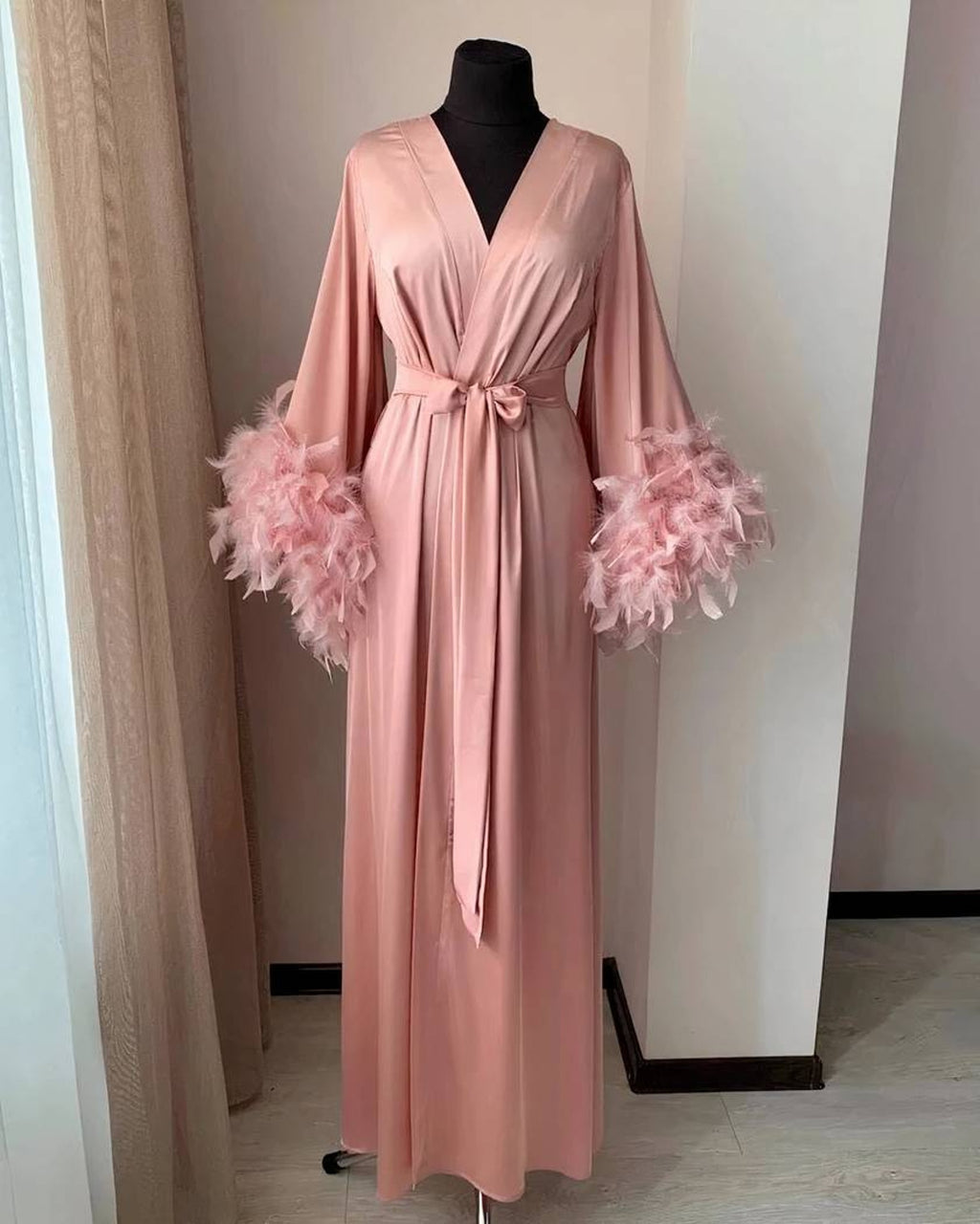 Le peignoir en rose, plumes assorties au poignet
