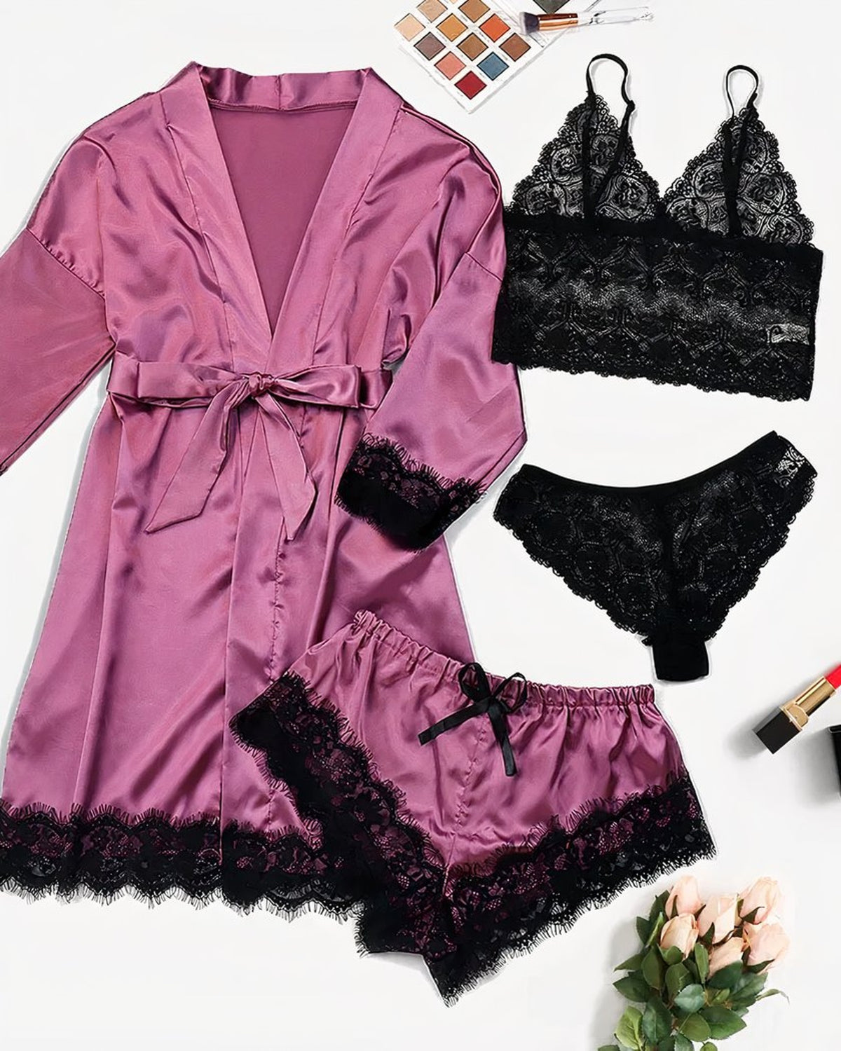 Ensemble lingerie quatre pièces rose et noir disposé à plat