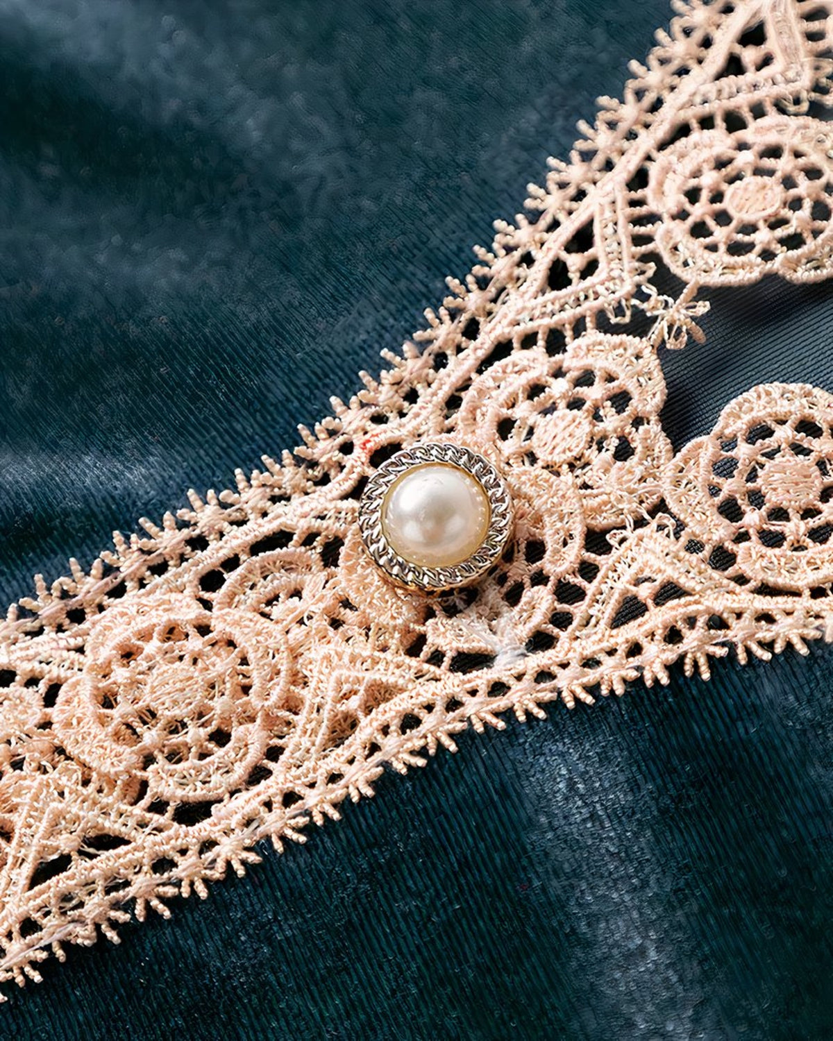Le bouton de nacre serti au haut du décolleté