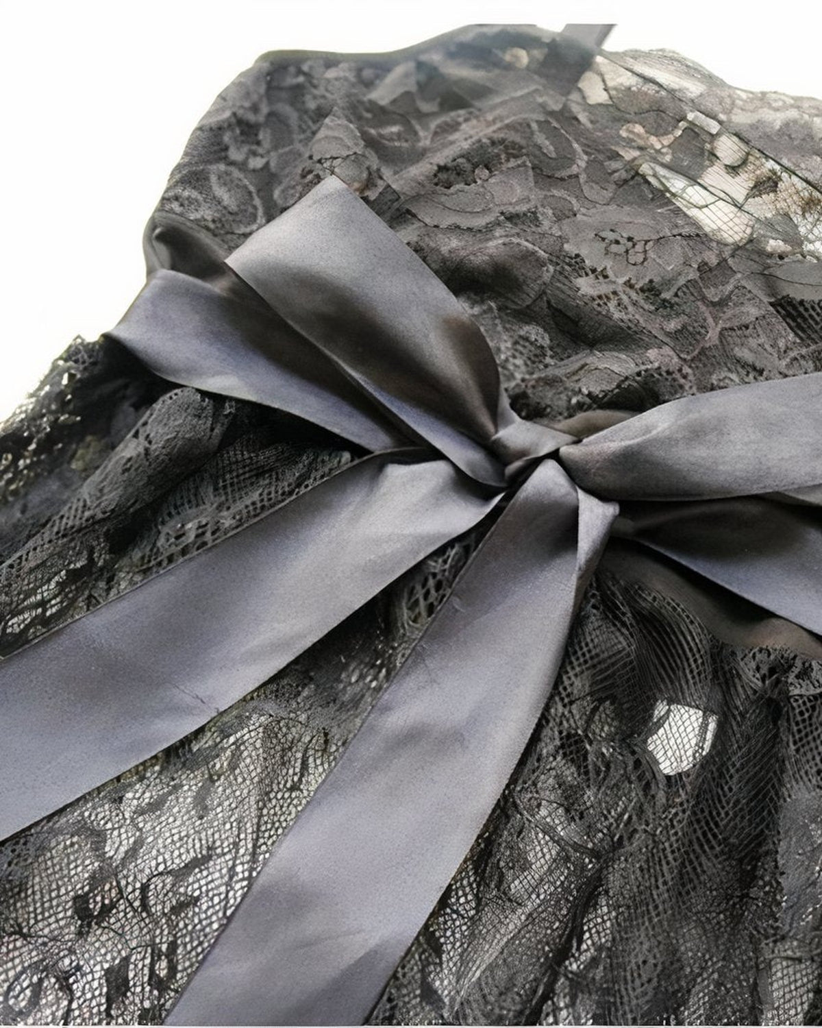 Le nœud de satin gris posé sur la dentelle florale