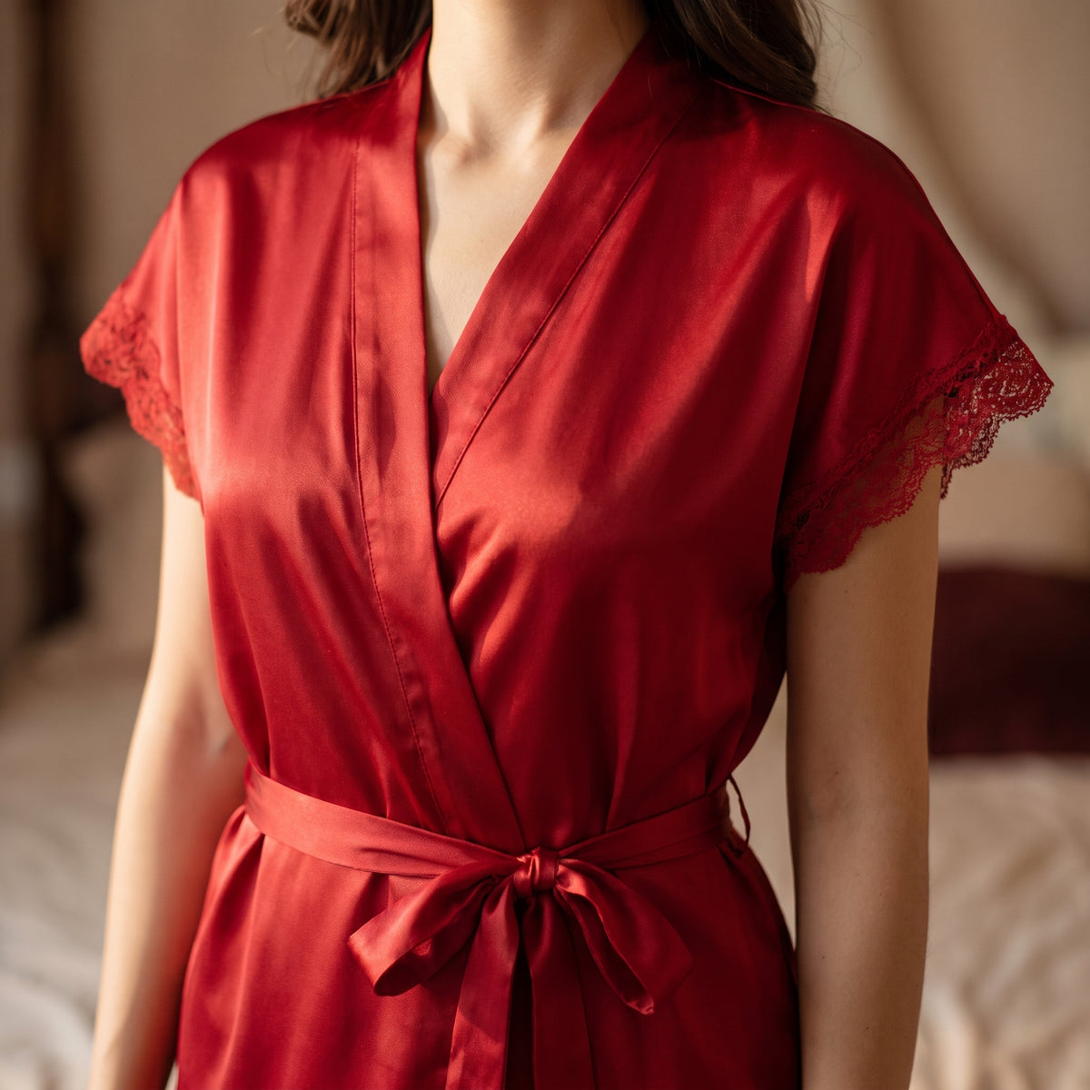 Détail du col en V croisé et de la dentelle fine des manches du kimono rouge