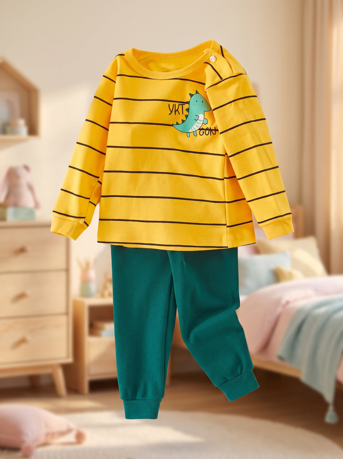 Ensemble pyjama garçon dinosaure présenté sans mannequin, haut jaune rayé et pantalon vert, dans une chambre d’enfant
