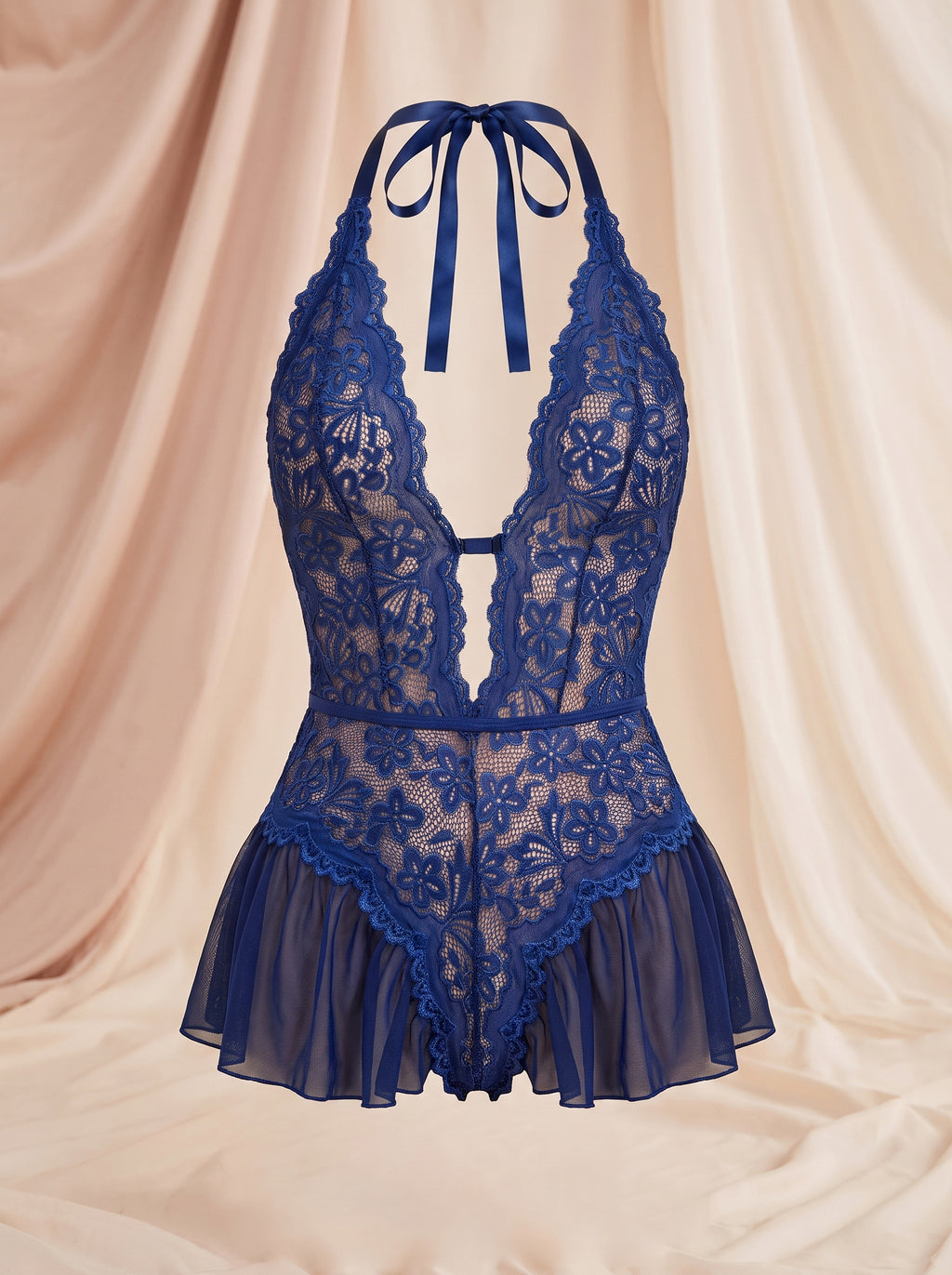 Nuisette bleue en dentelle et dos nu, décolleté en V et ruban noué à la nuque, vue de face