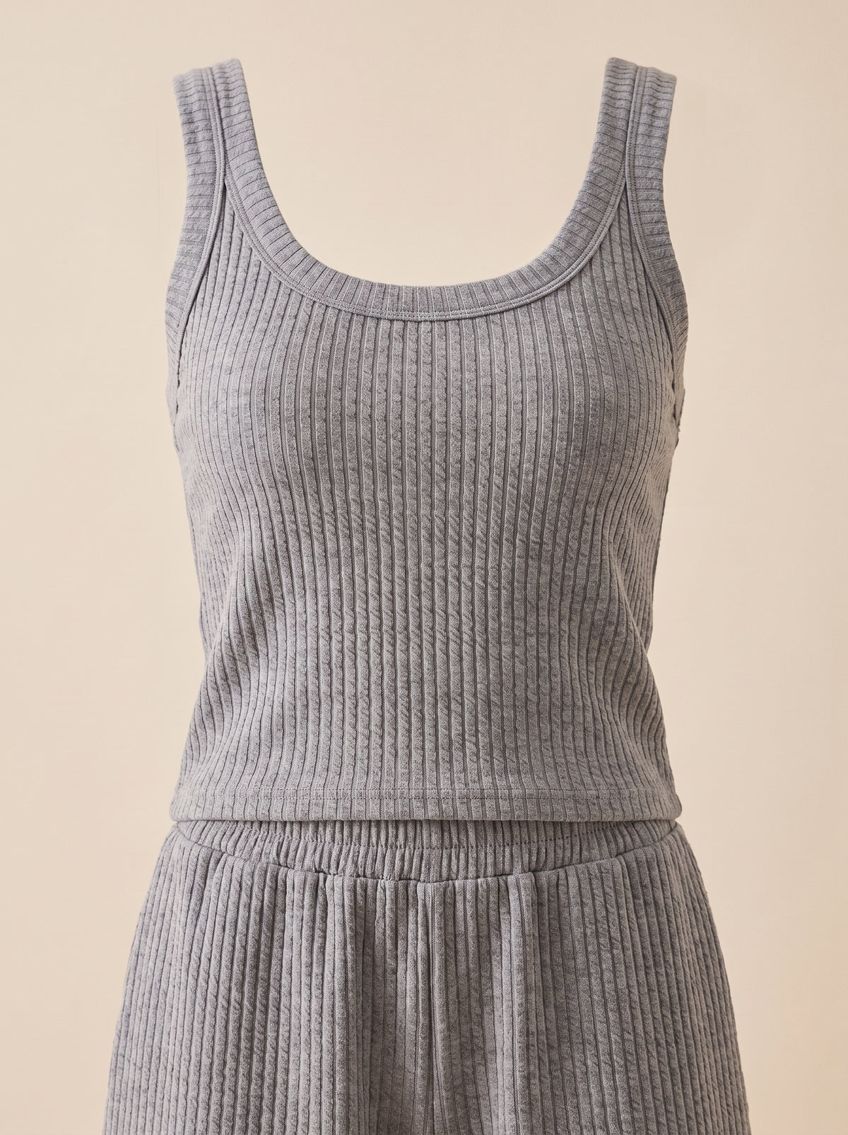 Pyjama deux-pièces en maille côtelée grise sur mannequin invisible, encolure ronde et taille élastiquée du short