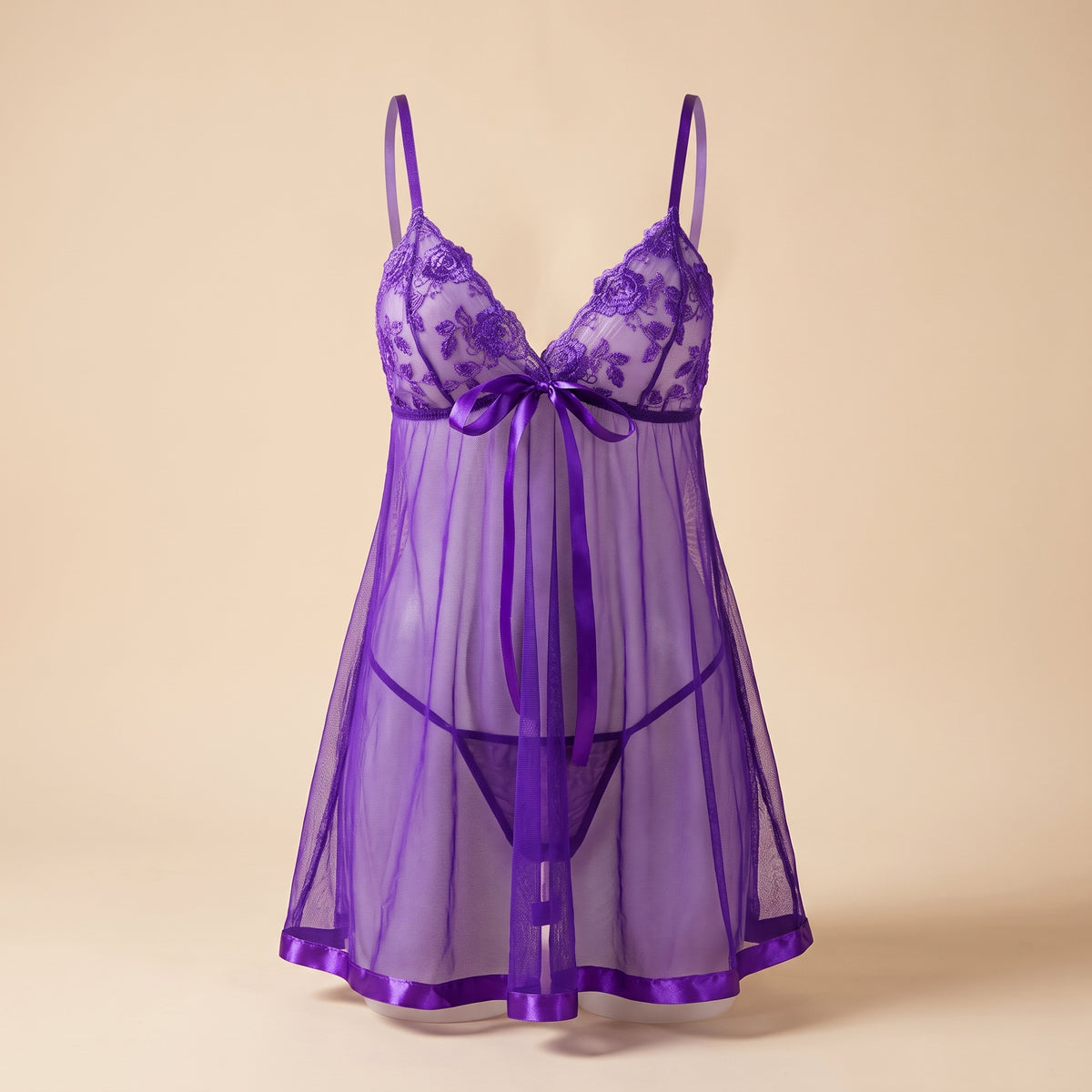Nuisette violette en dentelle transparente portee sur mannequin invisible, vue de face, coupe Empire avec noud en satin