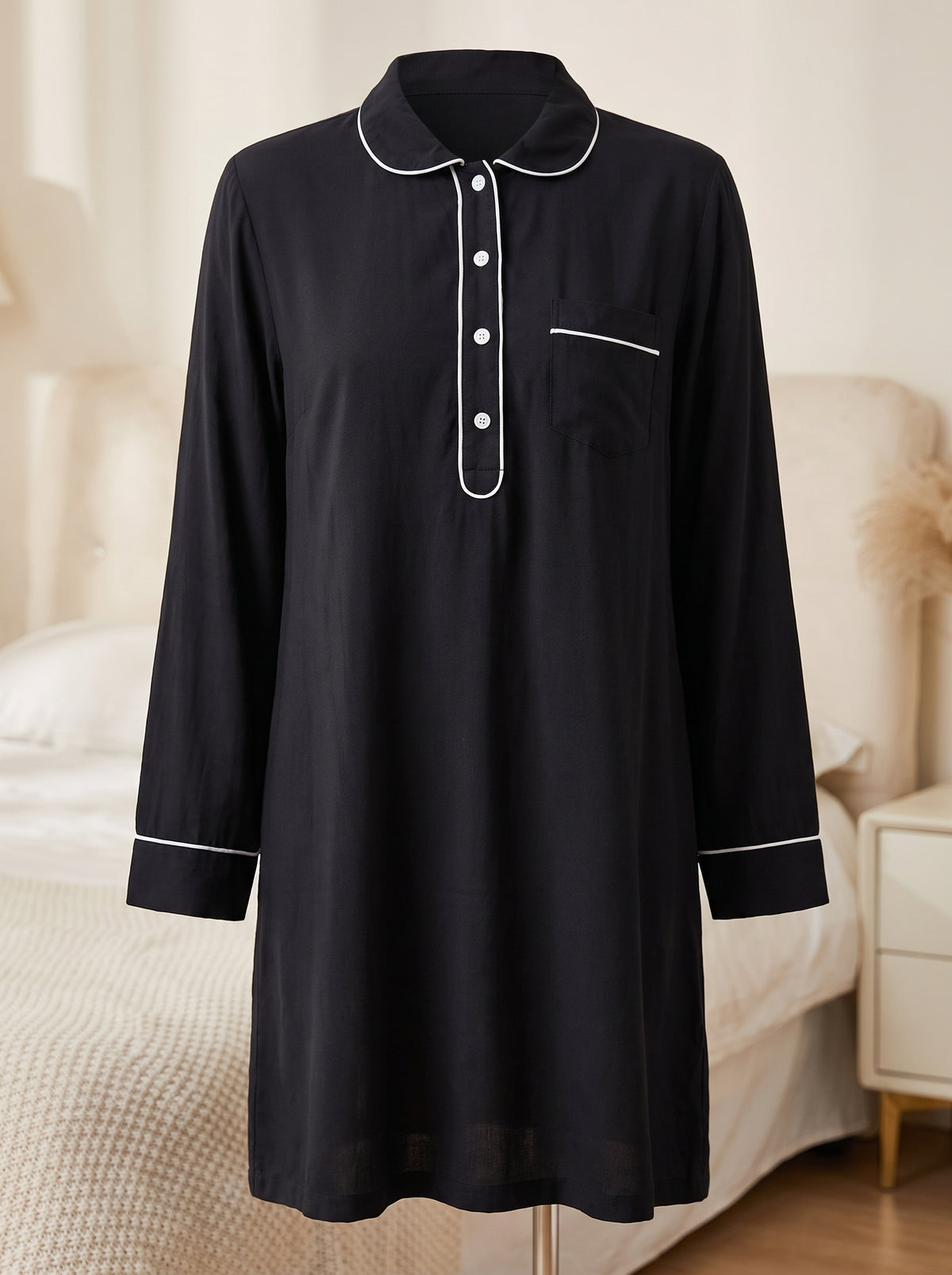 Chemise de nuit noire à passepoil blanc présentée de face sur buste