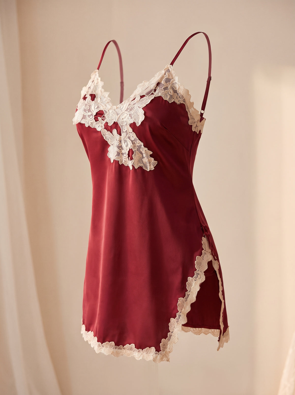 Nuisette en satin rouge bordeaux présentée sur mannequin invisible, fente sur le côté