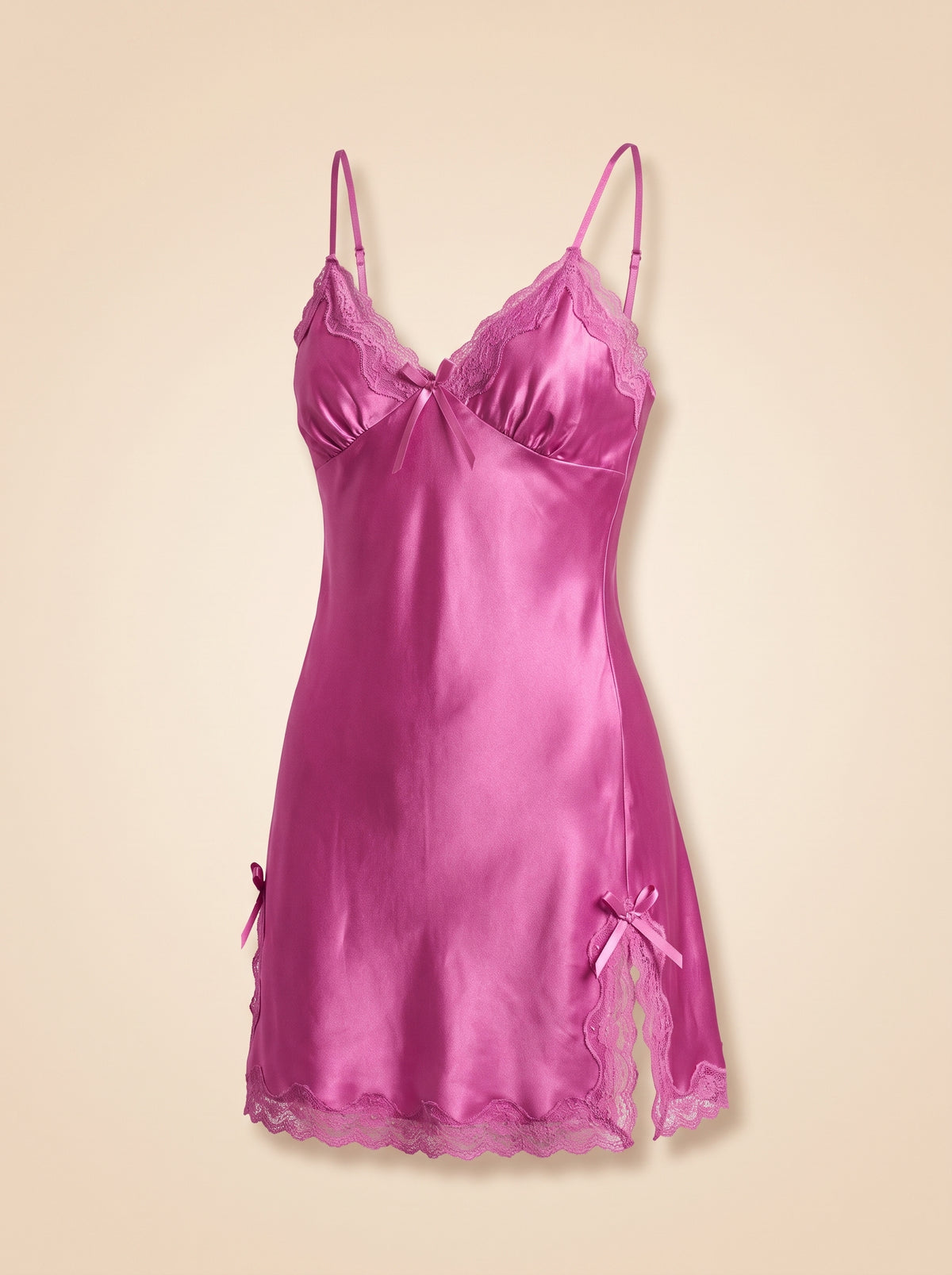 Nuisette en satin rose à dentelle et petits nœuds portée par mannequin invisible, vue de face