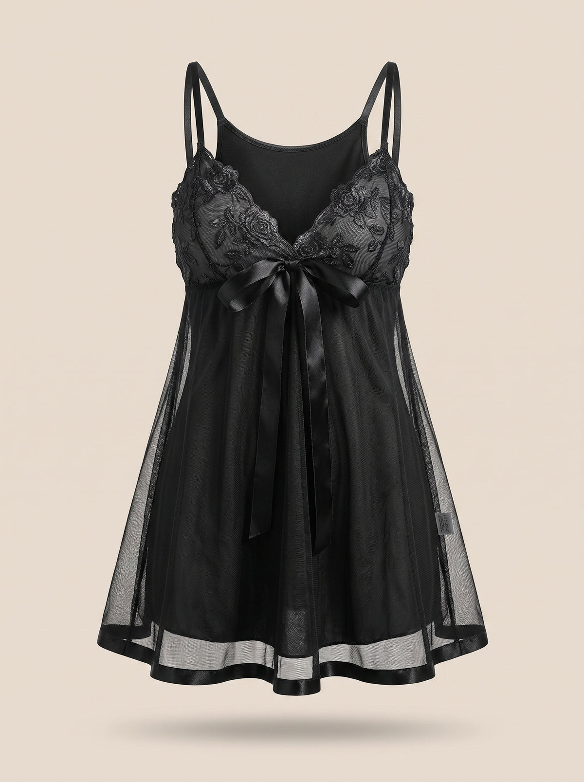 Nuisette noire en dentelle, vue de face sur mannequin invisible, coupe fluide et noeud satine
