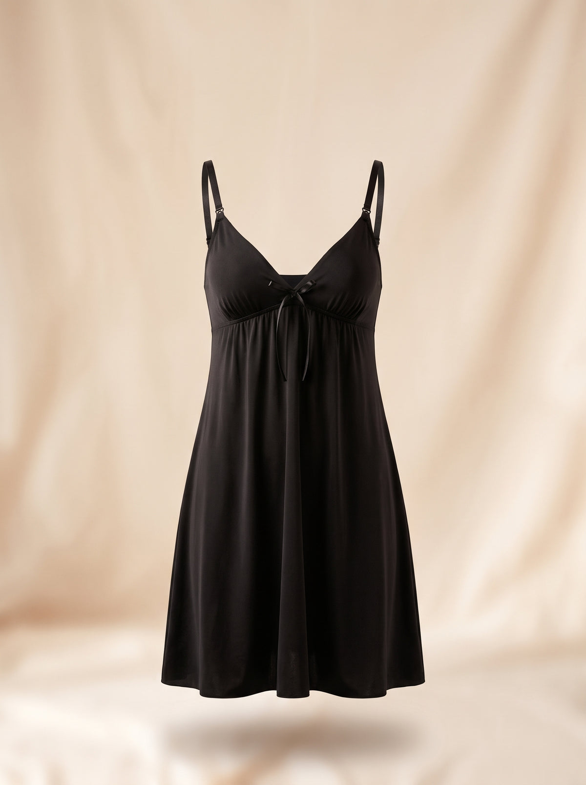 Nuisette d'allaitement noire présentée sur mannequin invisible, décolleté en V et nœud de satin
