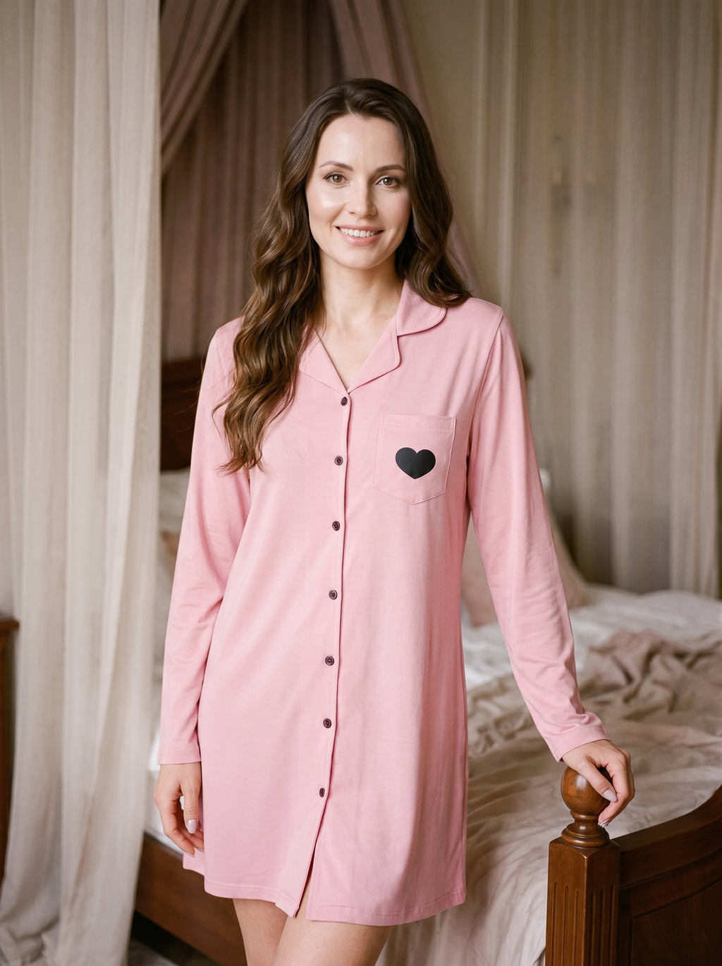 Femme souriante portant une robe de chambre courte rose boutonnée dans une chambre claire