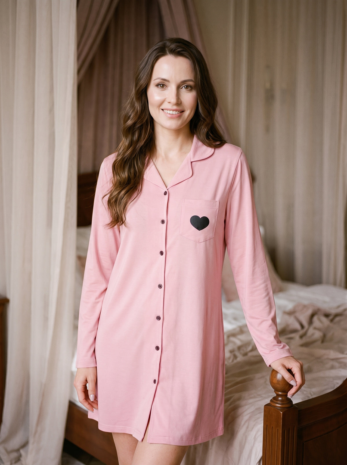 Femme souriante portant une robe de chambre courte rose boutonnée dans une chambre claire