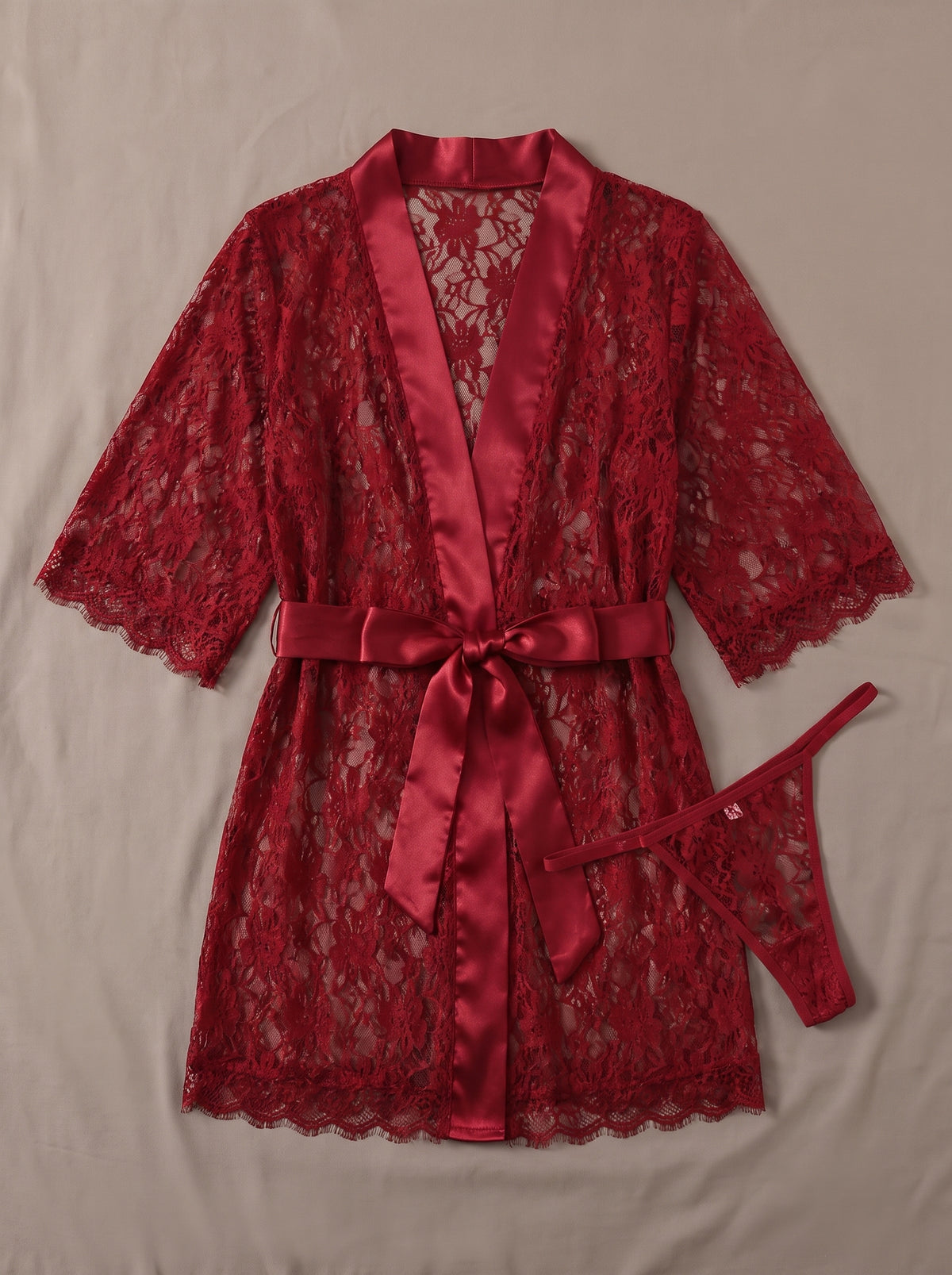 Nuisette kimono court en dentelle rouge transparente à ceinture satin, posée à plat