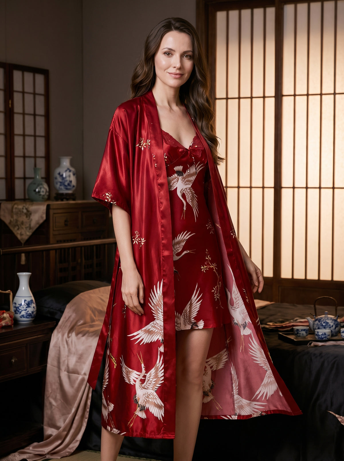 Ensemble nuisette et kimono long en satin rouge à imprimé grues, porté par une femme