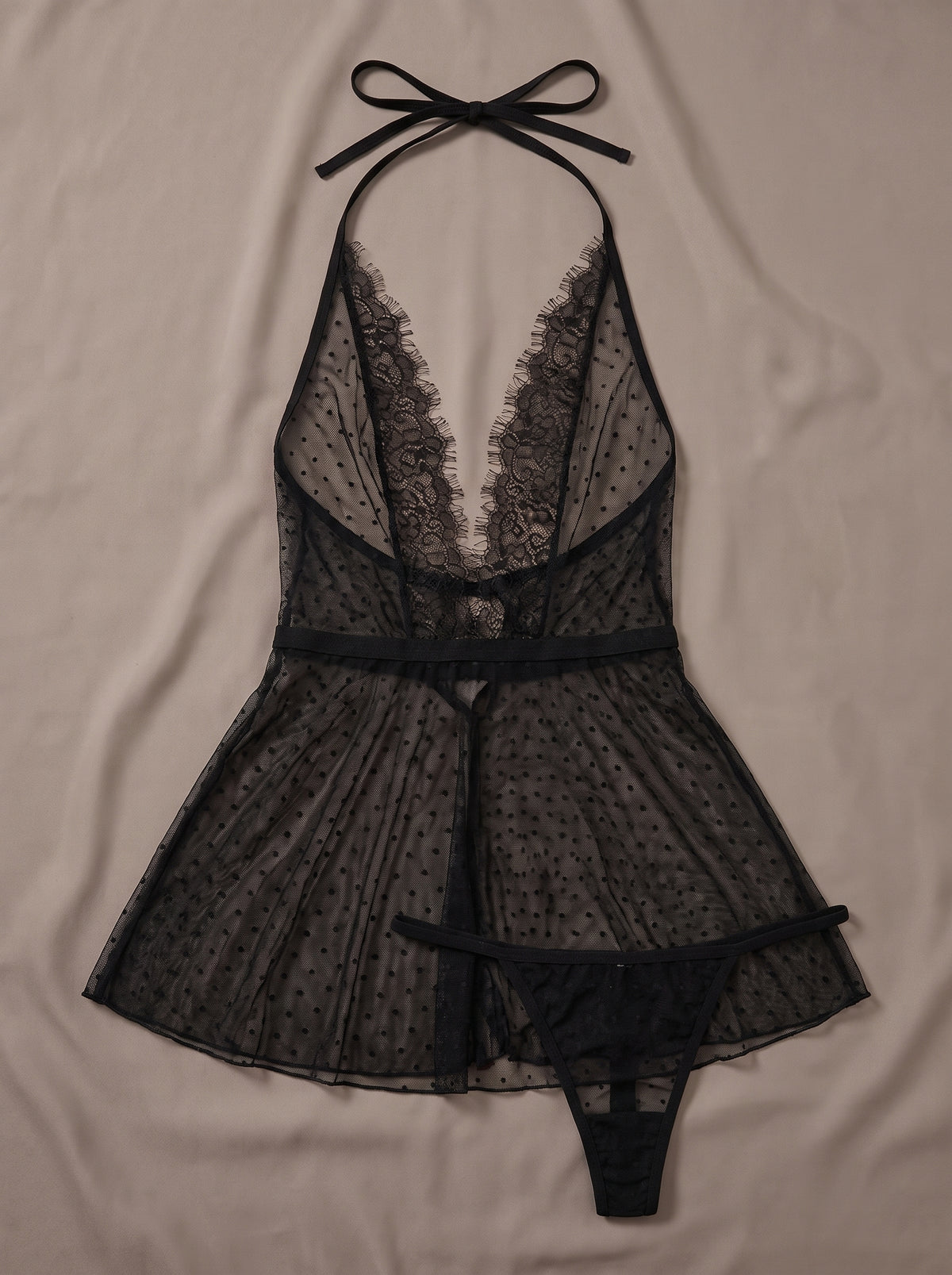 Nuisette babydoll noire en mesh à pois transparent à décolleté dentelle, posée à plat