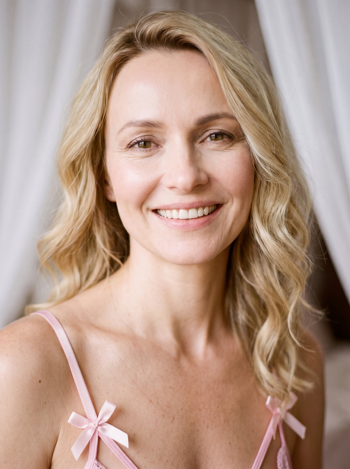 Nuisette rose en dentelle portée par une femme souriante