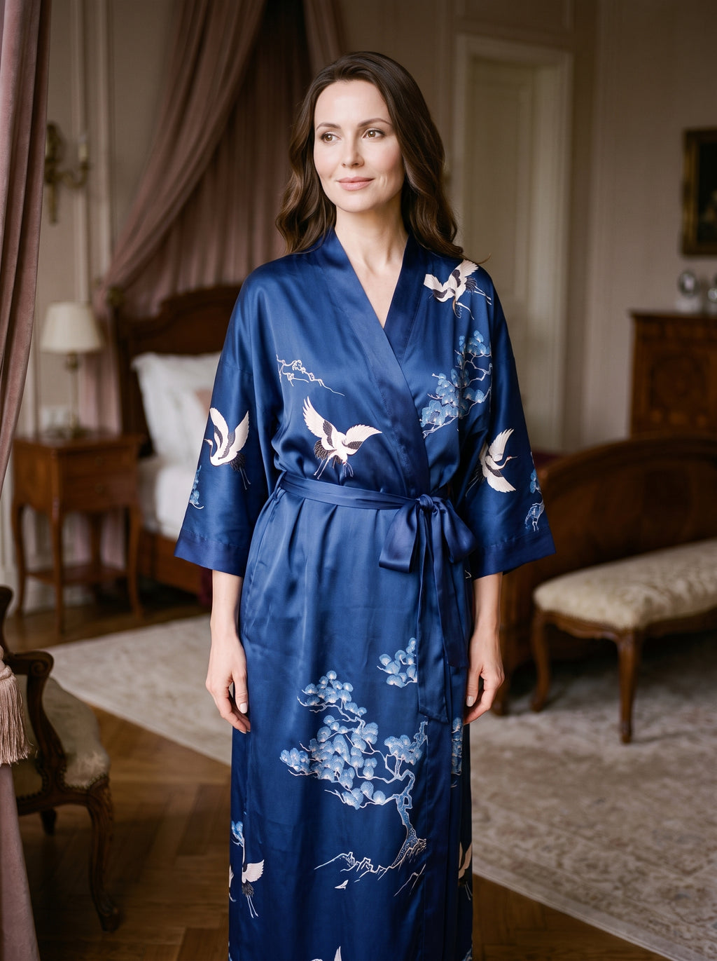 Femme en peignoir kimono satin bleu marine à motifs de grues, ceinturé