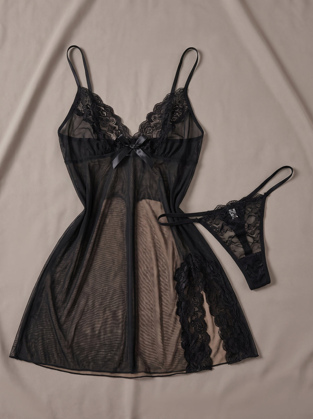 Nuisette babydoll noire en mesh transparent à décolleté dentelle, posée à plat