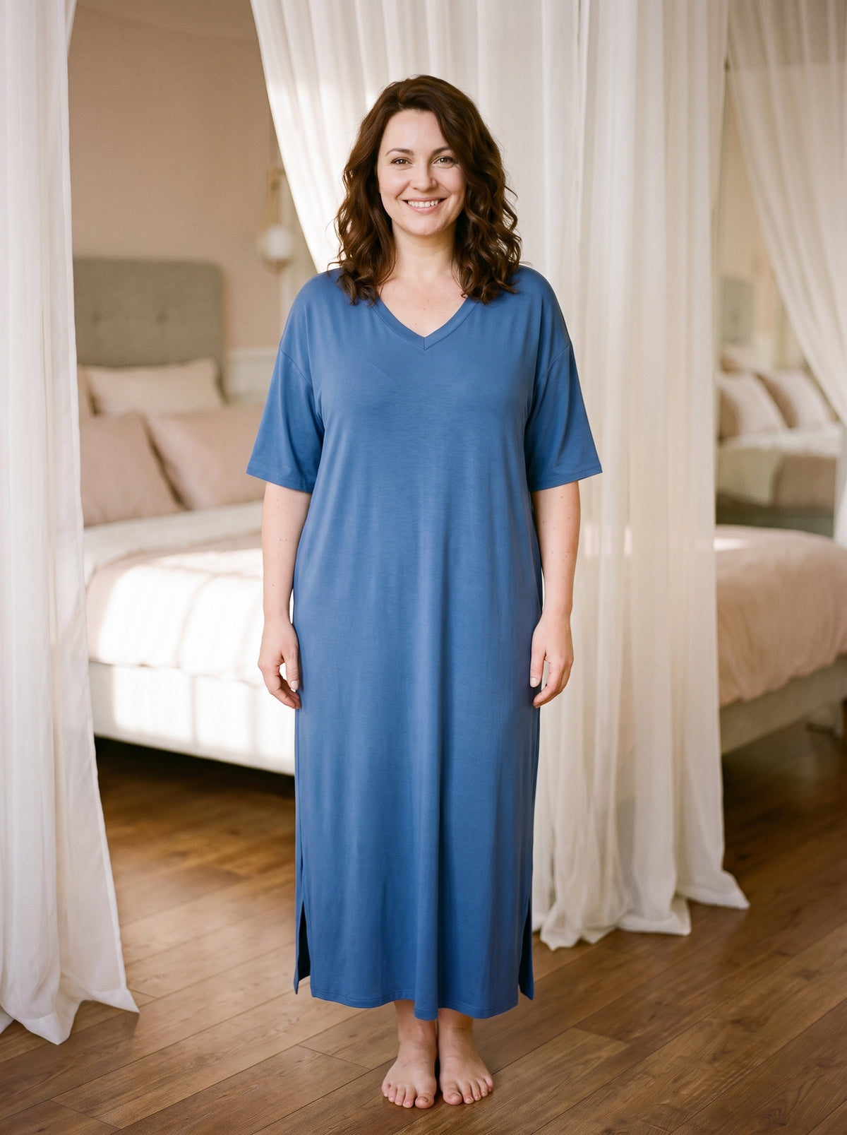 La chemise de nuit bleue portée par une femme souriante, en pied