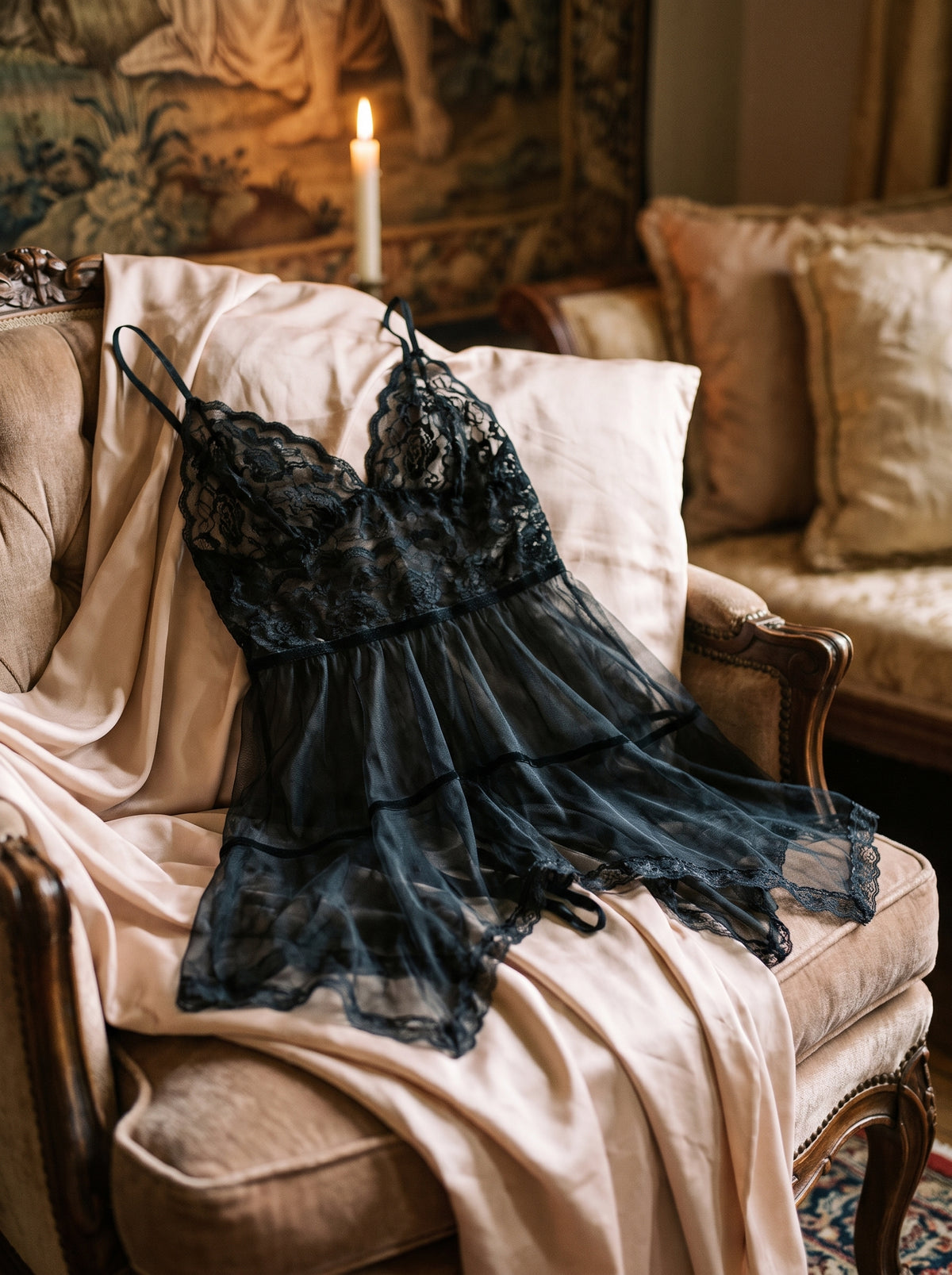 Nuisette noire en dentelle florale posée sur un fauteuil boudoir, ambiance tamisée et intime