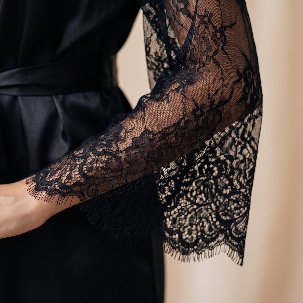Gros plan sur la dentelle florale noire de la manche du kimono