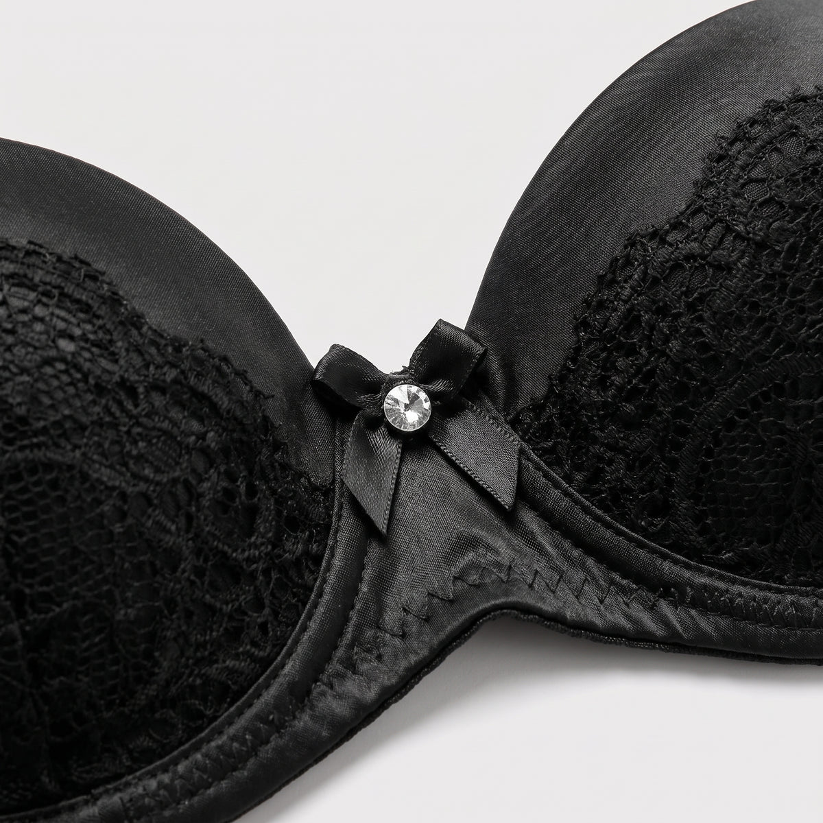 Détail du bonnet moulé en dentelle et du noeud à strass