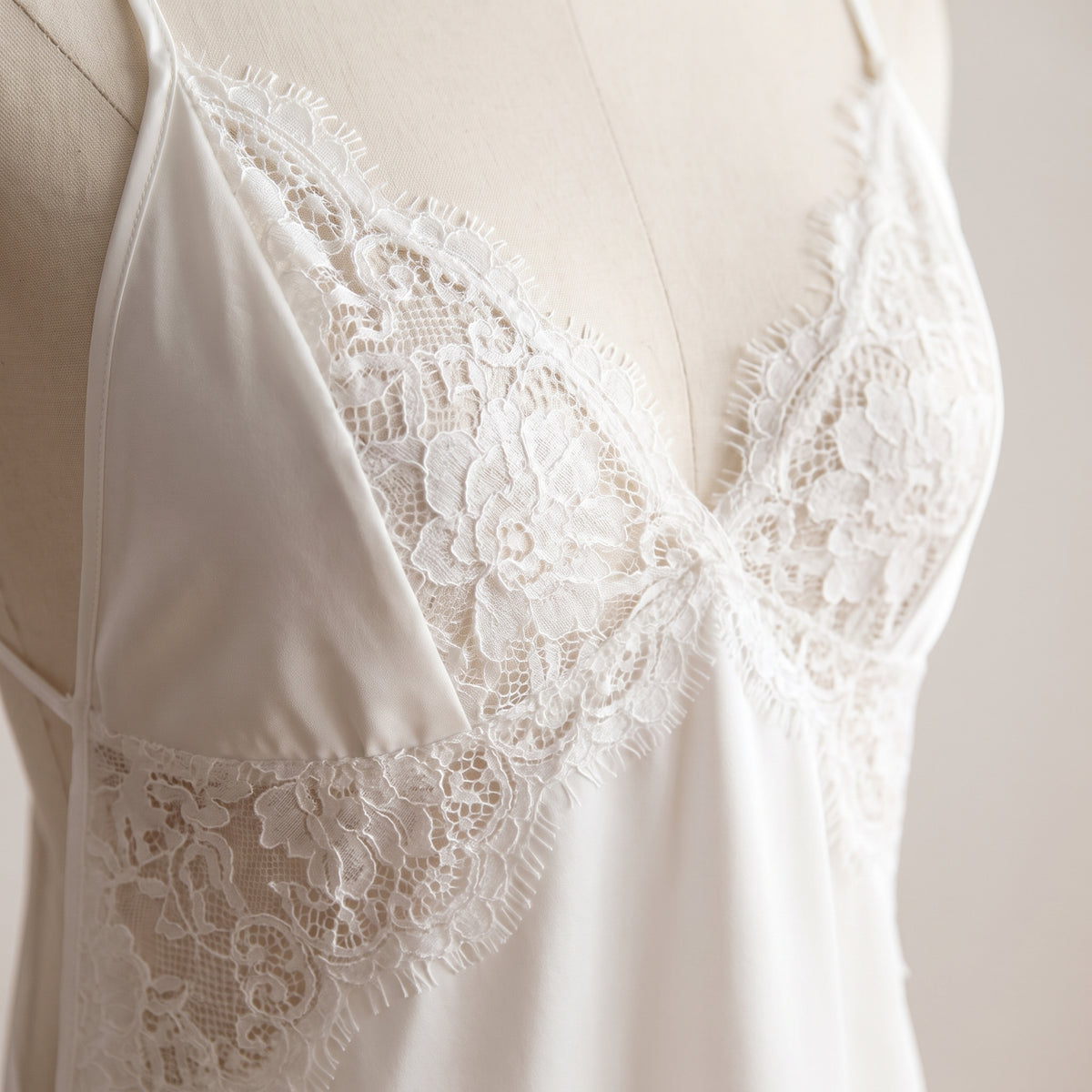 Détail des bonnets en dentelle florale blanche et du décolleté en V