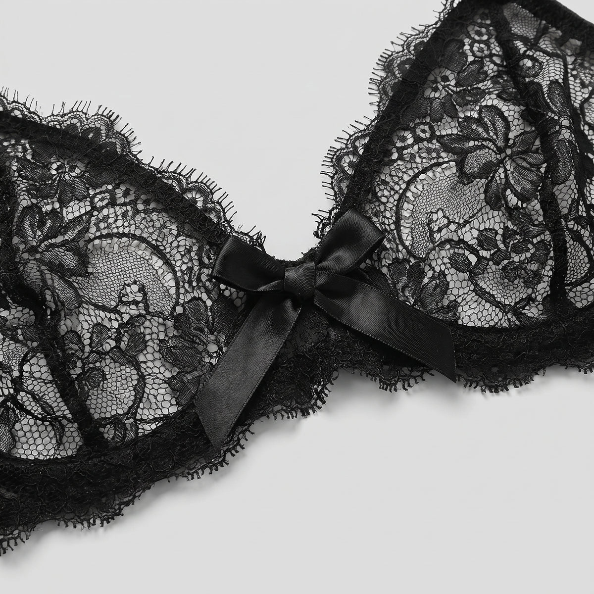 Détail des bonnets en dentelle florale et du noeud satin du décolleté en V