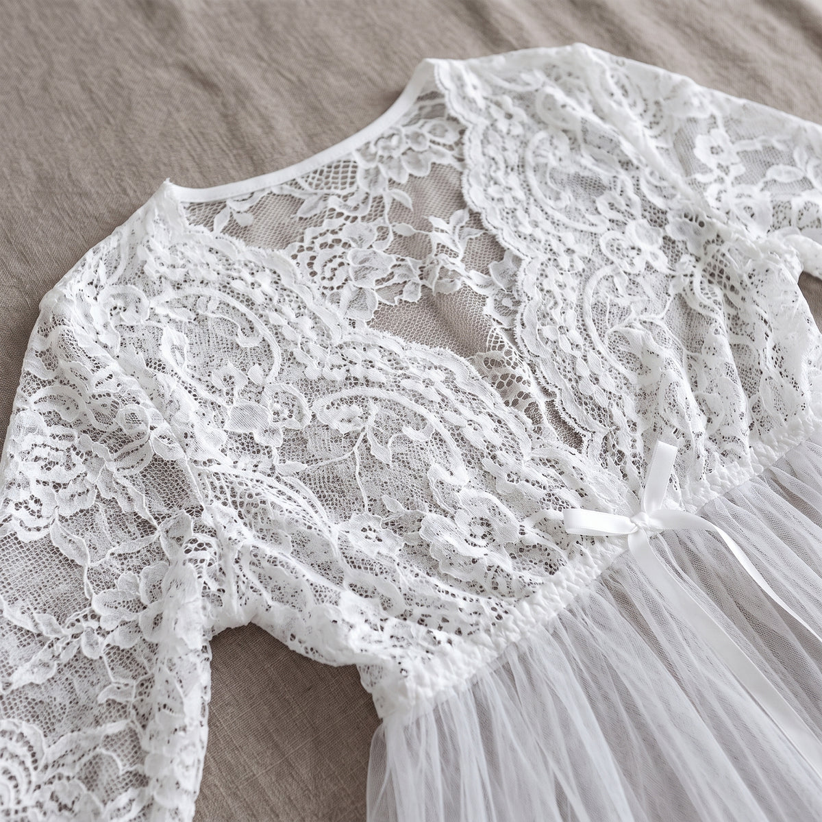 Détail du bustier en dentelle florale et du décolleté en V noué