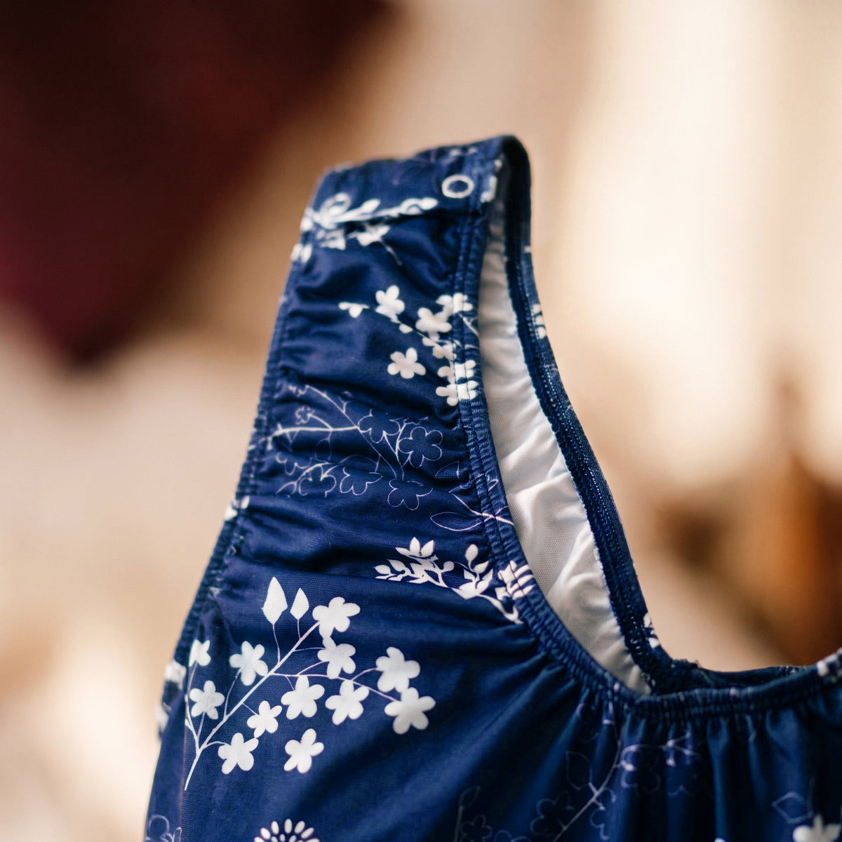 Patte à boutons-pression sur la bretelle froncée de la nuisette bleue, ouverture d'allaitement