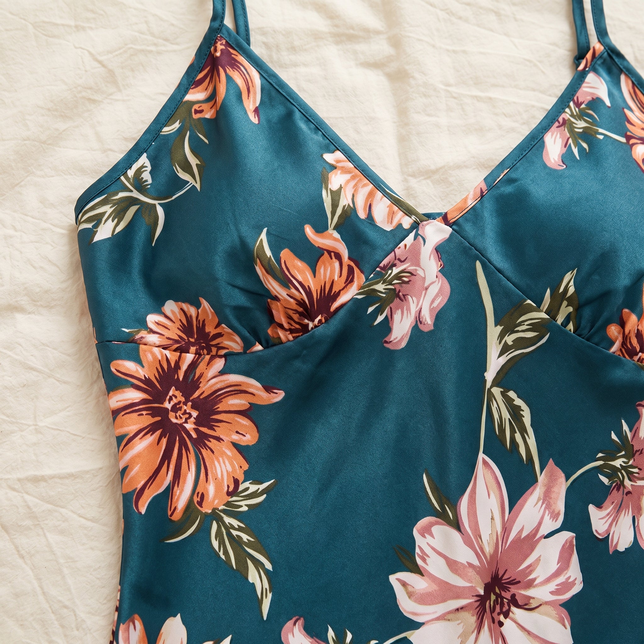 Décolleté en V du caraco et chrysanthème orange de l’imprimé vus de très près sur le satin Image