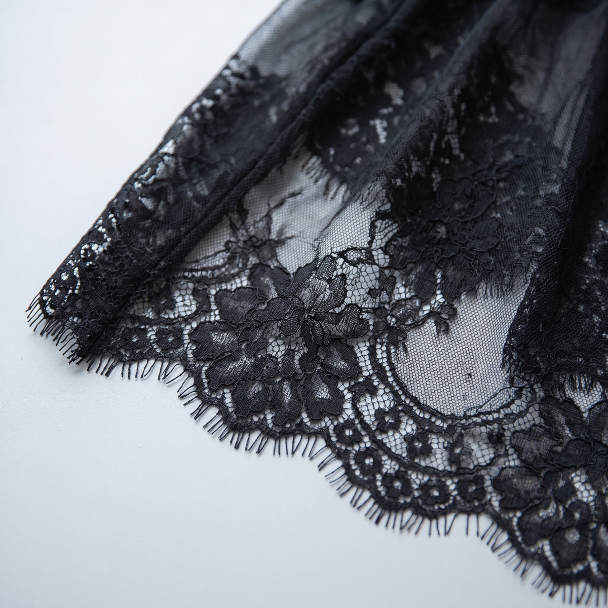 Détail de la dentelle florale ajourée et de l'ourlet festonné à picots