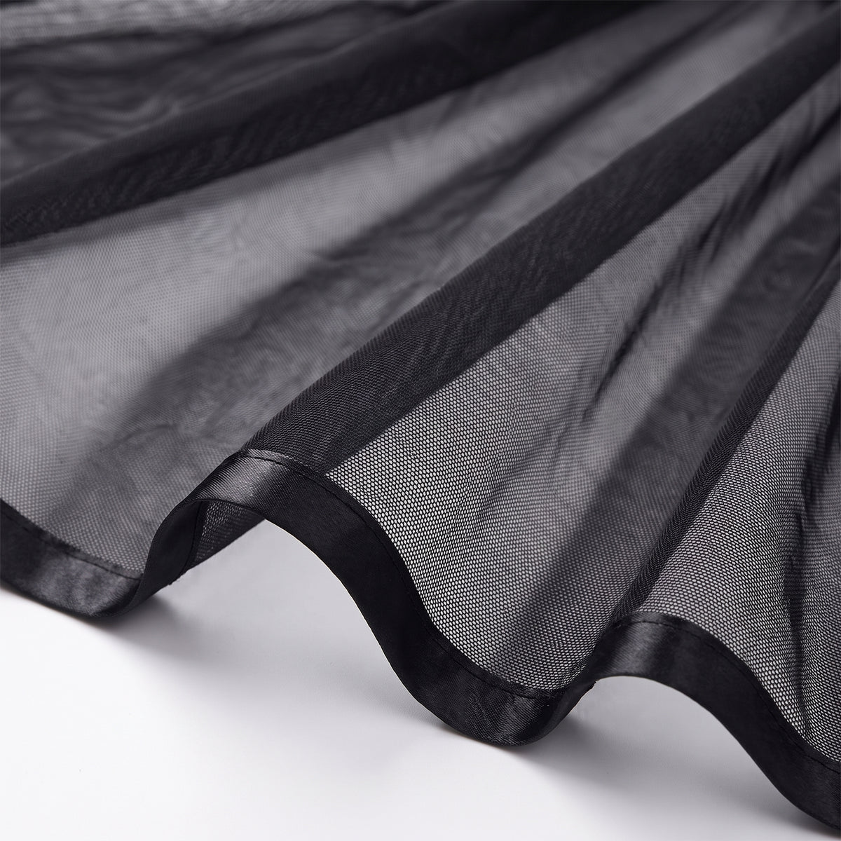 Détail de la jupe en voile mesh noir transparent et du biais satin
