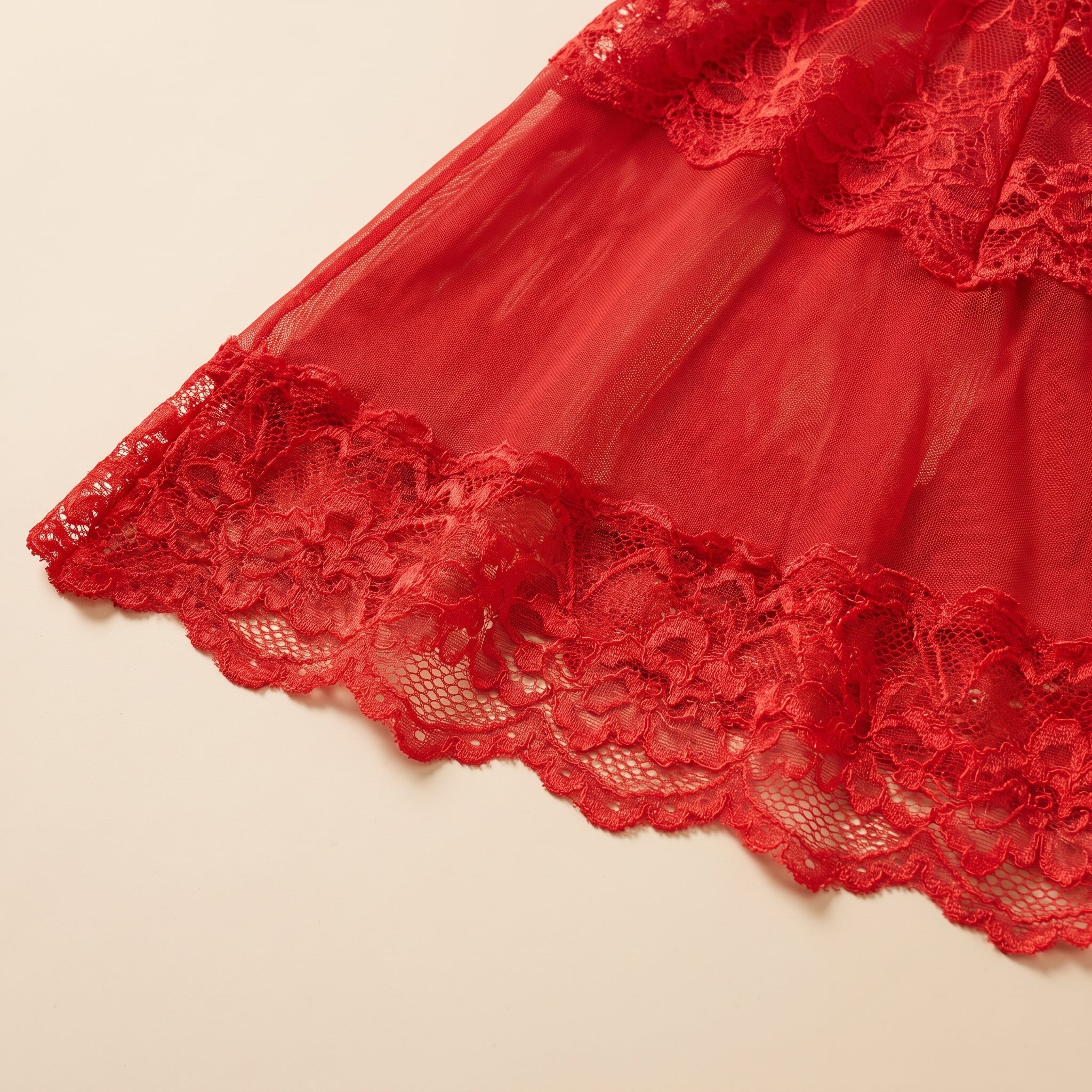Détail du voile transparent et de l'ourlet festonné en dentelle rouge Image