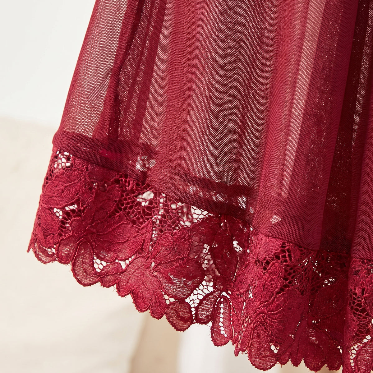 Détail du voile transparent et de l'ourlet en dentelle guipure rouge