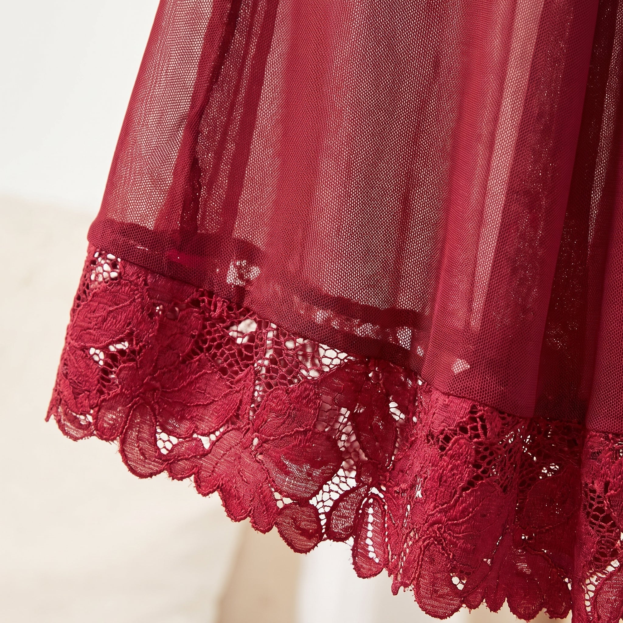 Détail du voile transparent et de l'ourlet en dentelle guipure rouge Image
