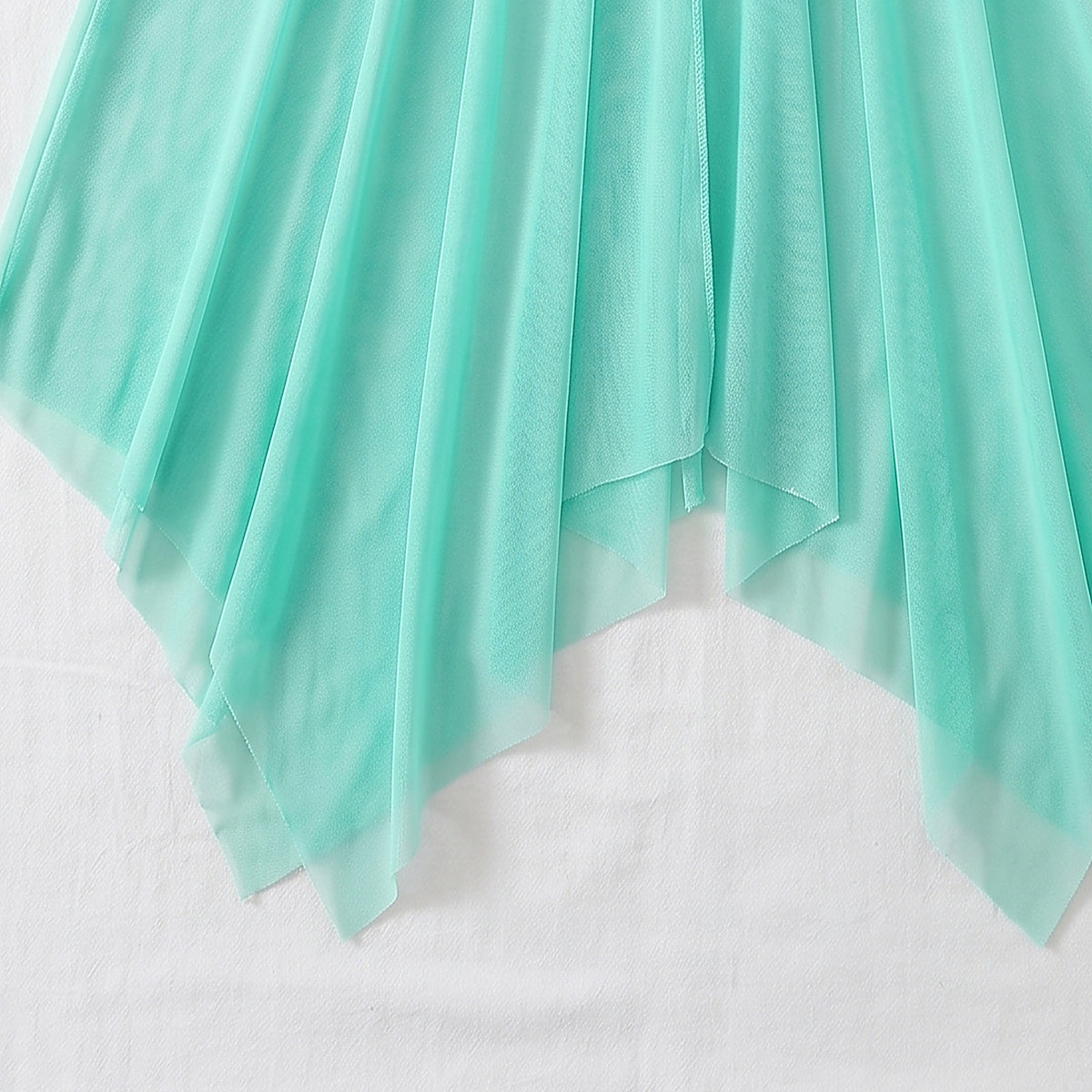 Détail du voile vert menthe transparent et de l'ourlet asymétrique en pointes