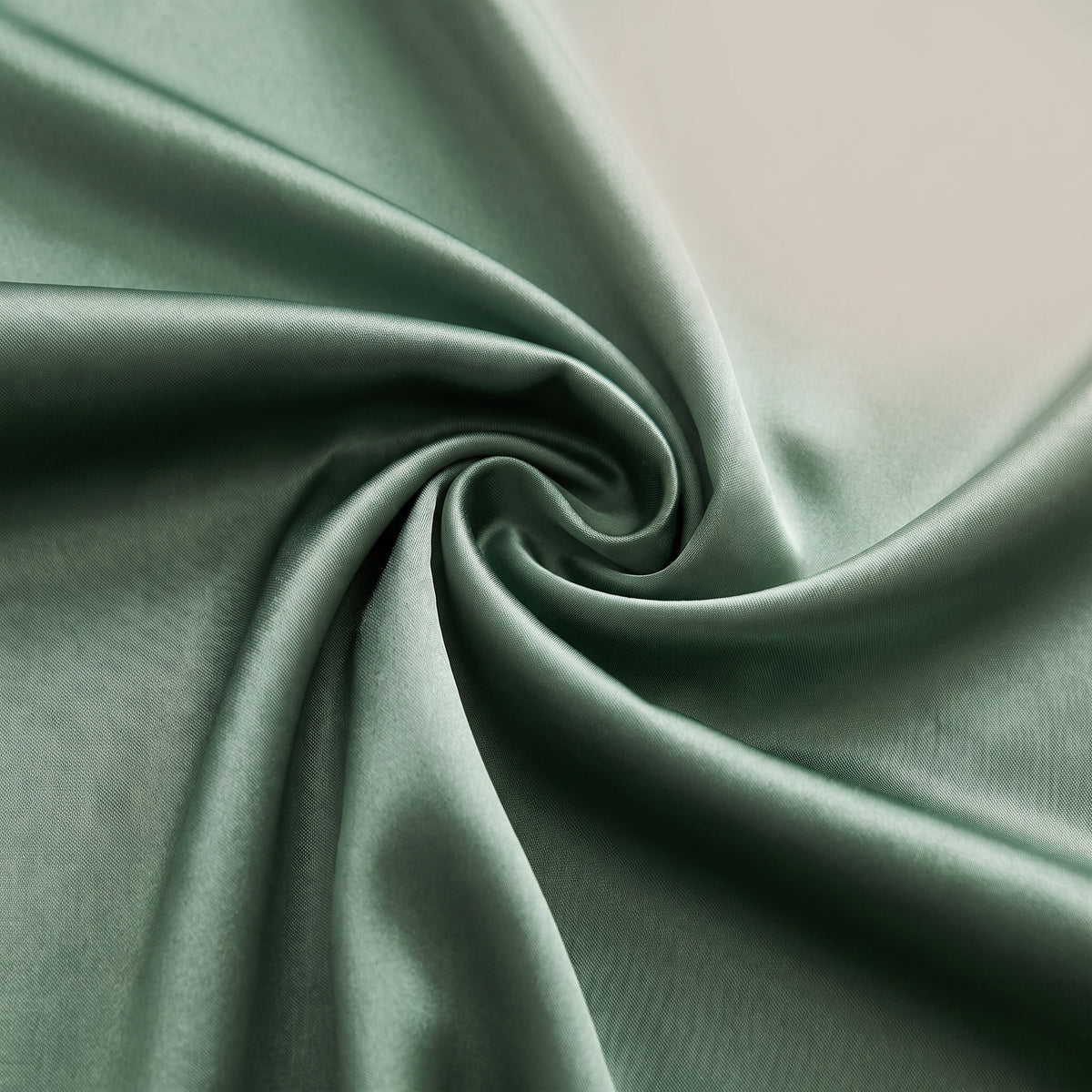 Détail du satin vert sauge lustré de la jupe