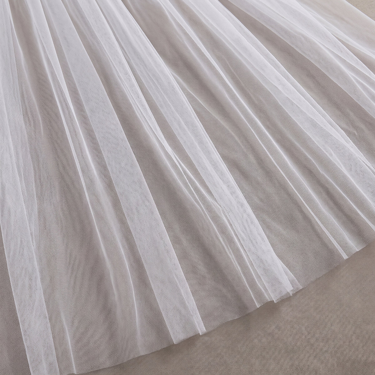 Détail du tulle blanc transparent de la longue jupe