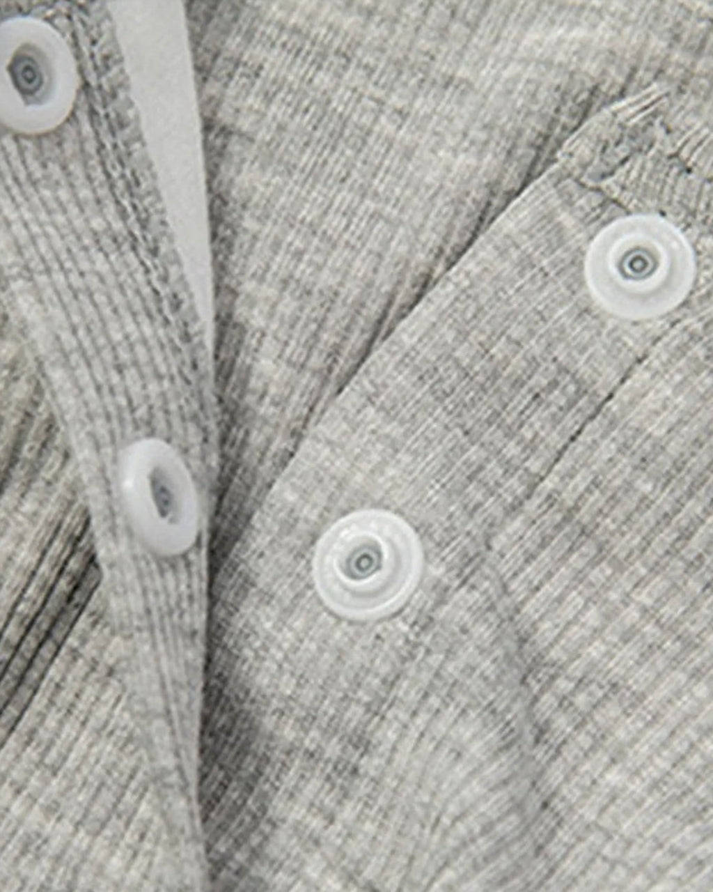 Gros plan sur la patte de boutonnage et la maille cotelee de la chemise de nuit de maternite
