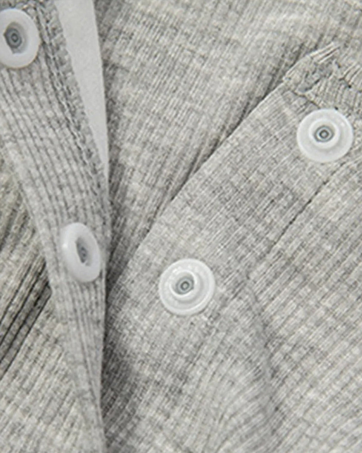 Gros plan sur la patte de boutonnage et la maille cotelee de la chemise de nuit de maternite