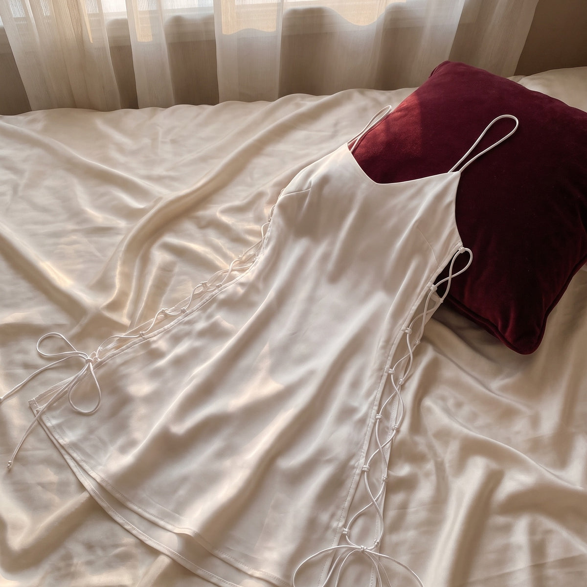Nuisette blanche en satin sur lit boudoir, vue carree pour bloc