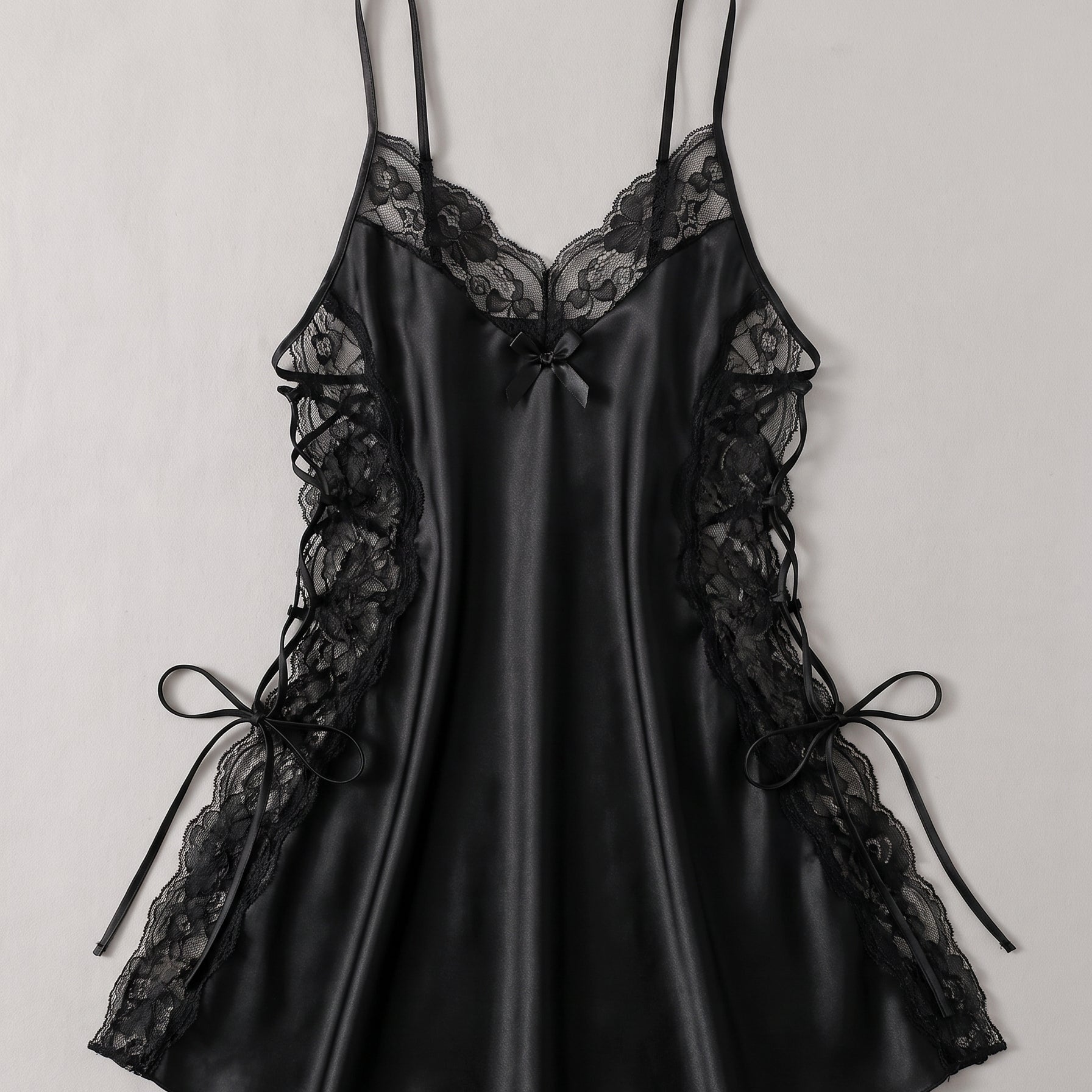 Le noir, mystère et sensualité — Nuisette en satin noir à col en V et côtés lacés Image