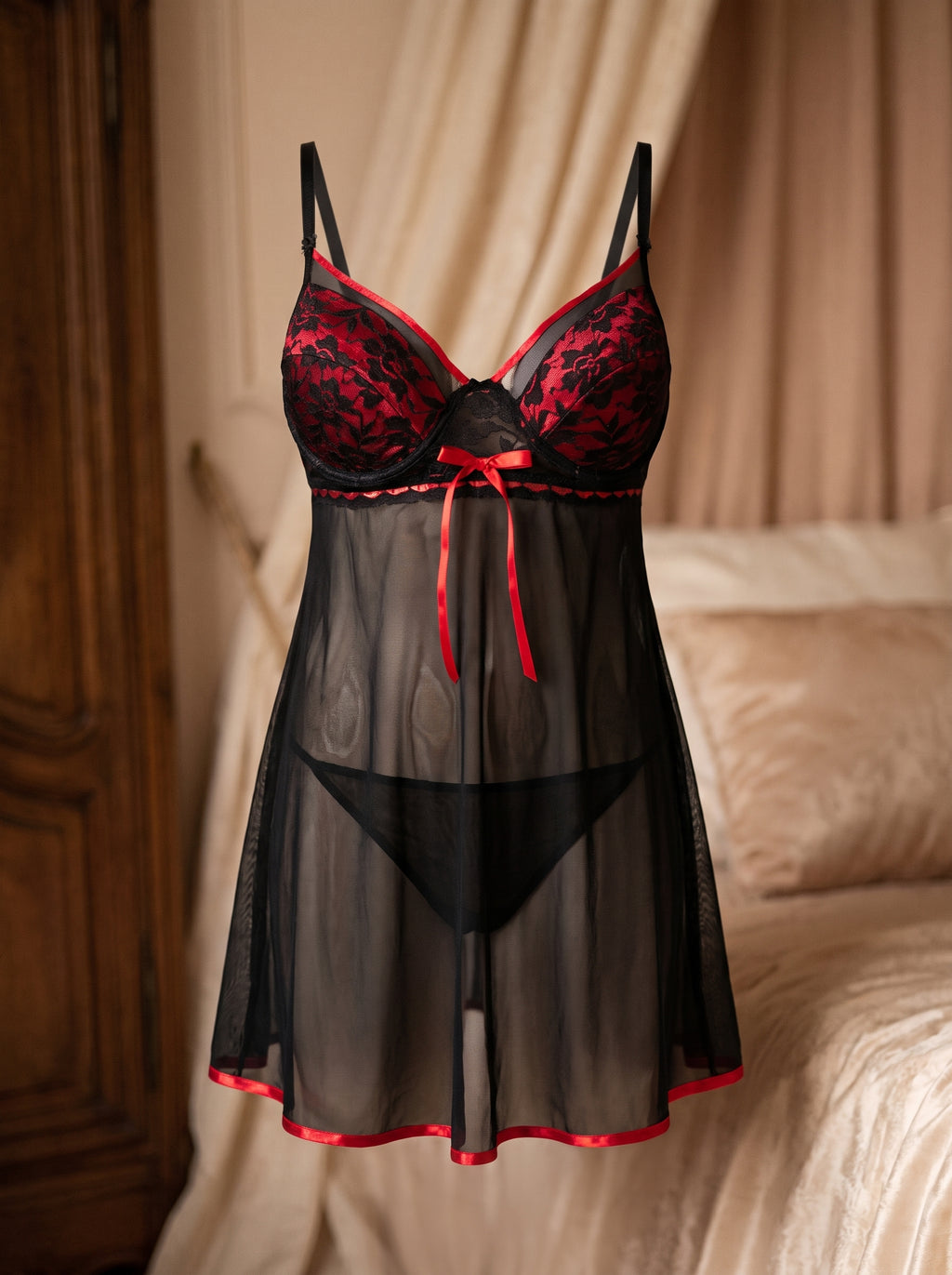 Nuisette grande taille en dentelle noire et ruban rouge portée sur mannequin invisible