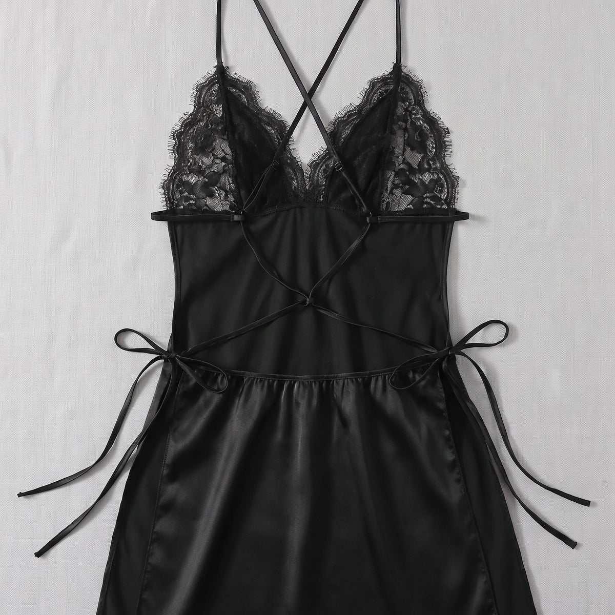 Le noir, mystère et sensualité — Nuisette en satin noir à dentelle, dos nu et fendue