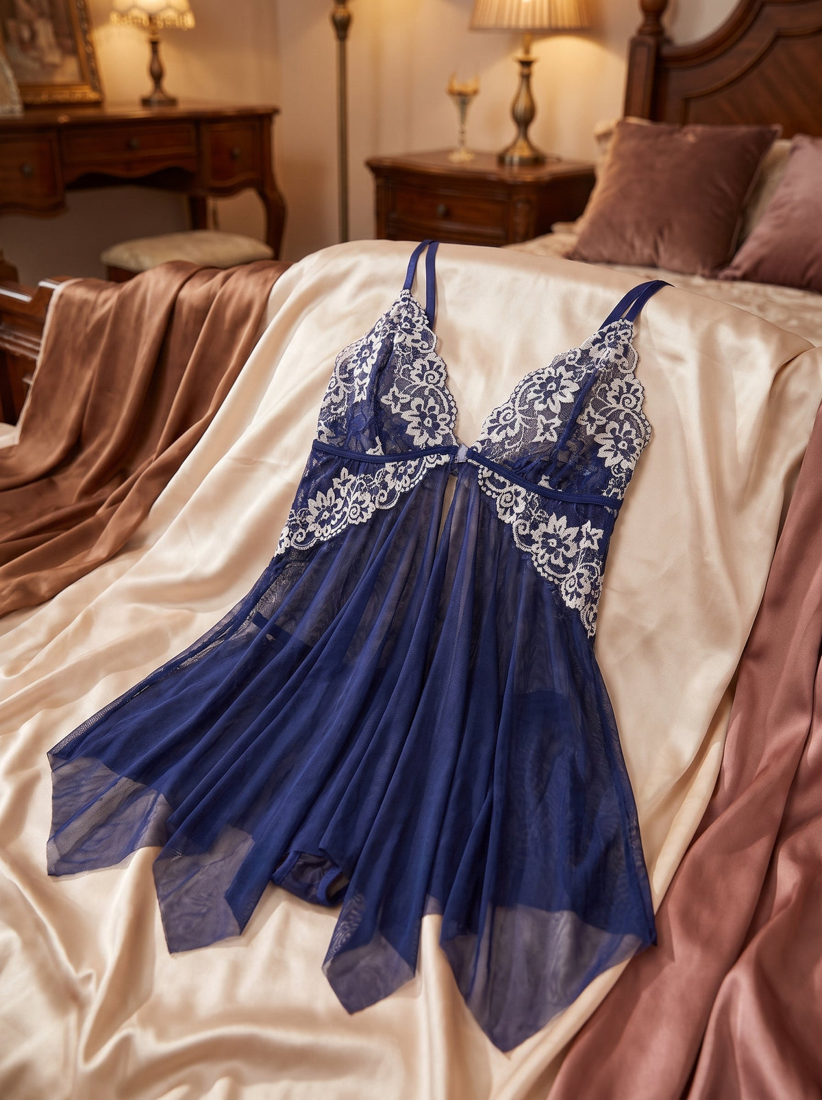 Nuisette bleue en dentelle présentée à plat sur satin crème